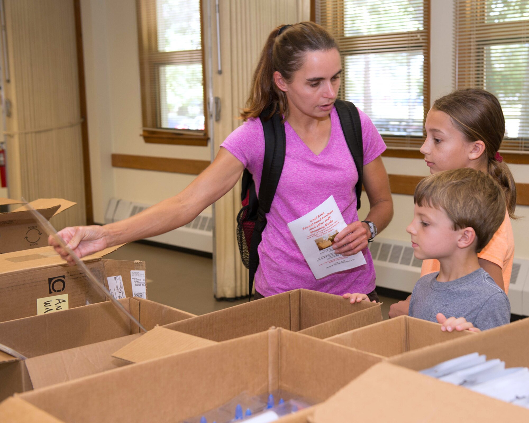 HANSCOM AIR FORCE BASE, Mass. – Yvonne Teal and her two children, 6-year old CJ and 9-year old Emily, collect school supplies during a Back to School Social at the chapel here Aug. 27. The Hanscom First Sergeant Council and Family Advocacy scheduled the Back To School Social for families with students going back to school to receive free school supplies and have the opportunity to meet other families. (U.S. Air Force photo by Mark Herlihy)
