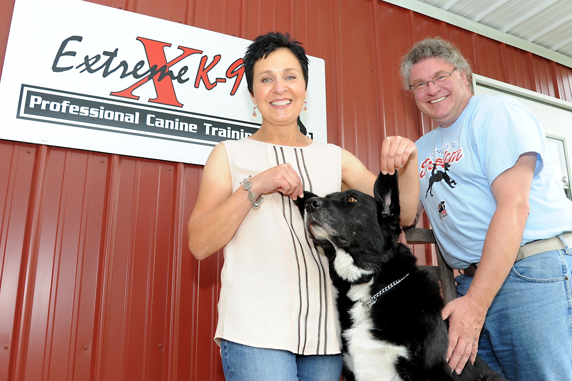 Behesha Doan, founder and training director of This Able Vet, K-9 Mama and her owner Matthew Mihelcic, retired military service member, pose for a photo trained at Extreme K-9, Aug. 16, 2014 at Carbondale, Ill. Doan used her experiences to build This Able Veteran as a way to give back to veterans, to not just thank them but to help empower vets to take their lives back. (U.S. Air Force photo/ Senior Airman Tristin English)