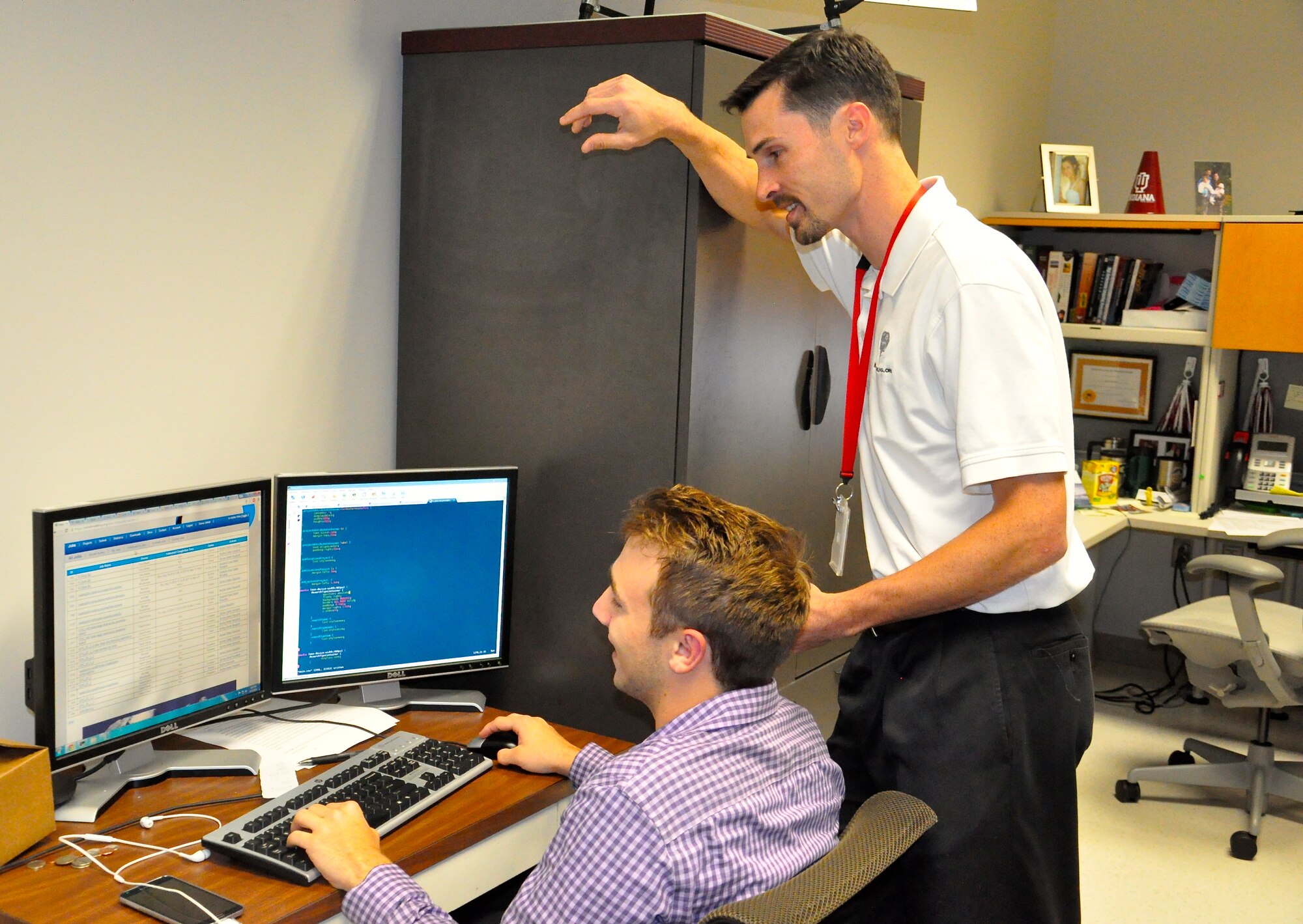 Air Force Research Laboratory’s 711th Human Performance Wing employee, Dr. Jack Harris, research computer scientist and cognitive scientist for the 711 HPW’s Cognitive Models and Agents branch,  offers guidance to his summer intern, Nathan Neitman, a computer science student at Sinclair Community College. “This really expanded my research environment,” said Neitman, of his time in Harris’s lab at the 711th HPW, Wright-Patterson Air Force Base. Harris was recently awarded the AFMC-level DOD CIO award for individual accomplishment in calendar year 2014. Harris received the award for his work in developing computational capability that not only speeds the pace of cognitive modeling research, but fundamentally changes the level of complexity of research questions that can be asked – making this a true game changer for complex modeling and analysis.  (Air Force photo by Michele Eaton)

