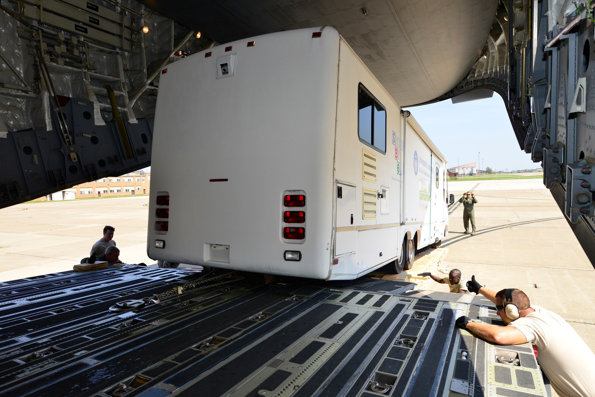 Members of the 30th Aerial Port Squadron, load a mobile dental clinic donated by the Flying Dentists Association, onto a C-17 aircraft from joint base McGuire, N.J., August 26, 2014, Niagara Falls Air Reserve Staion, N.Y. The Air Force will transport this vehicle via the Denton Cargo Program, an amendment which allows the U.S. Military to transport donated goods on a space available basis. The dental clinic is bound for the Dominican Republic where it will service approximately 30,000 people in need. (U.S. Air Force photo by Staff Sgt. Stephanie Sawyer)  