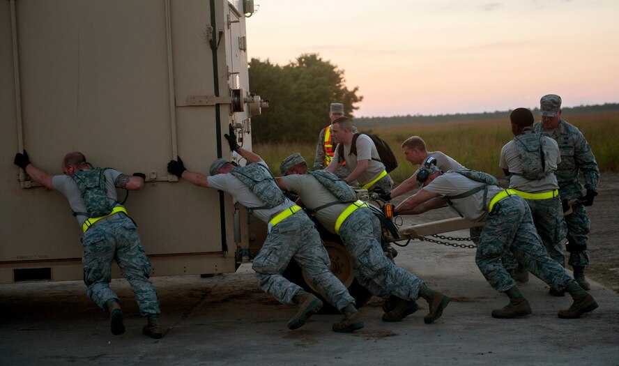 JOINT BASE MCGUIRE-DIX-LAKEHURST, N.J. - Airmen from the 571st Contingency Response Group at Travis Air Force Base, Calif., push a hardside expandable light air-mobile shelter into position during Eagle Flag 14-4 at Lakehurst Naval Air Station Aug 18, 2014. The 571 CRG and 689th Rapid Port Opening Element (RPOE) from Joint Base Langley-Eustis, Va., participated in the Eagle Flag 14-4, from Aug. 15-22. Together, they form the Joint Task Force-Port Opening and specialize in quickly establishing operations, providing security, tracking cargo and personnel, and moving supplies from the aircraft to customers quickly and efficiently. Week 1 of Eagle Flag, 14-3, was held Aug. 8-11 and consists of the 818th Contingency Response Group from Joint Base McGuire-Dix-Lakehurst, N.J. and the 689 RPOE. 
(U.S. Air Force Photo by Tech. Sgt. Matthew Hannen/Released) 
