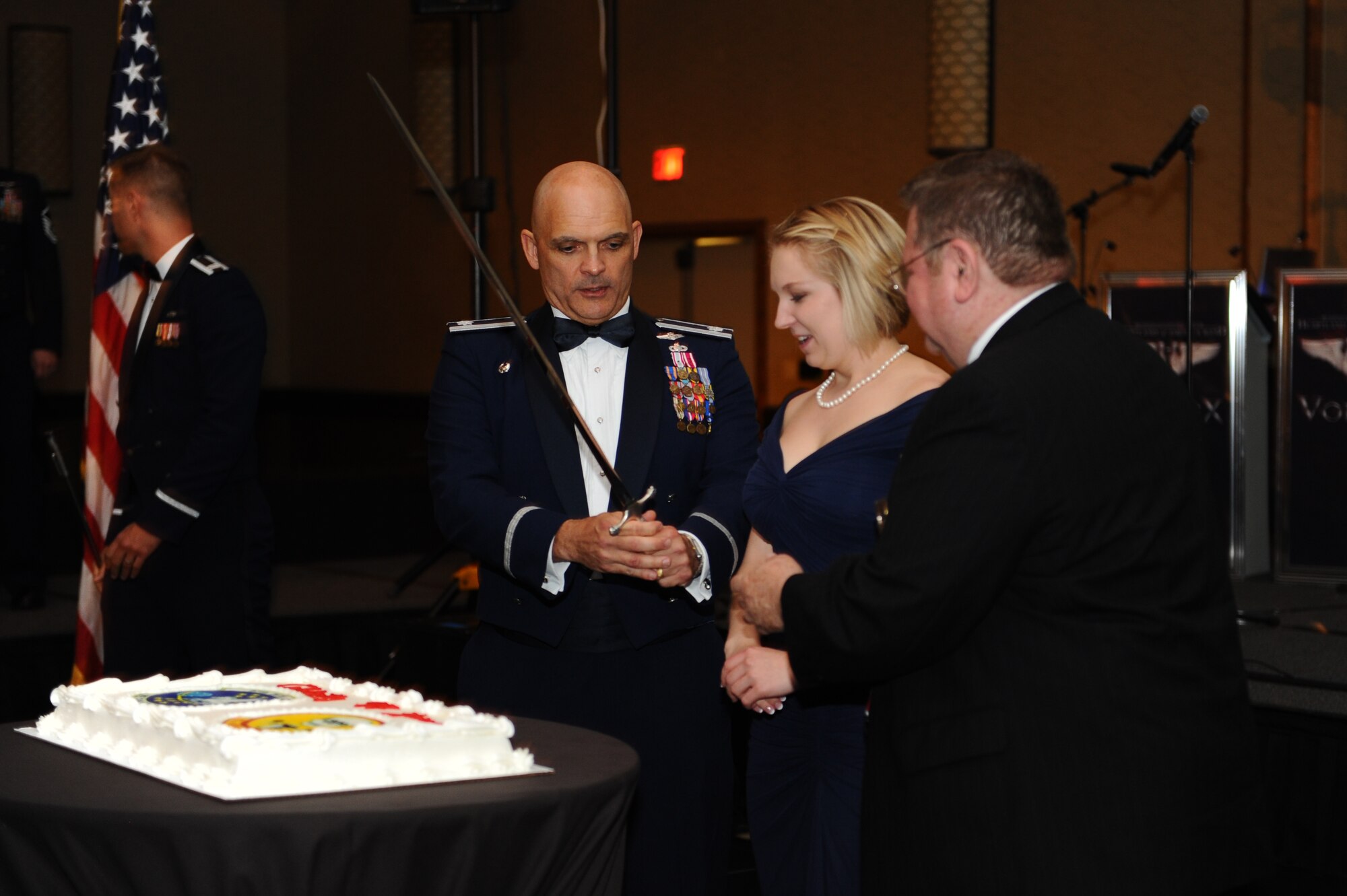 U.S. Air Force Lt. Col. Evan Smith, 97th Intelligence Squadron commander, U.S. Air Force Senior Airman Lauren Pigney, the youngest Airman in the 97th IS, and retired U.S. Air Force Col. Bob Cope, who commanded the 6949th Electronic Security Squadron, cut the squadron birthday cake at the 97th IS Heritage Ball held in Omaha on Aug. 22. Nearly 400 past and present 97th IS members attended the heritage ball where retired U.S. Air Force Col. Kerry Taylor, former 97th IS commander and current director of Ohio Aerospace Hub, was keynote speaker. (U.S. Air Force photo by U.S. Tech. Sgt. Jered Poloa)