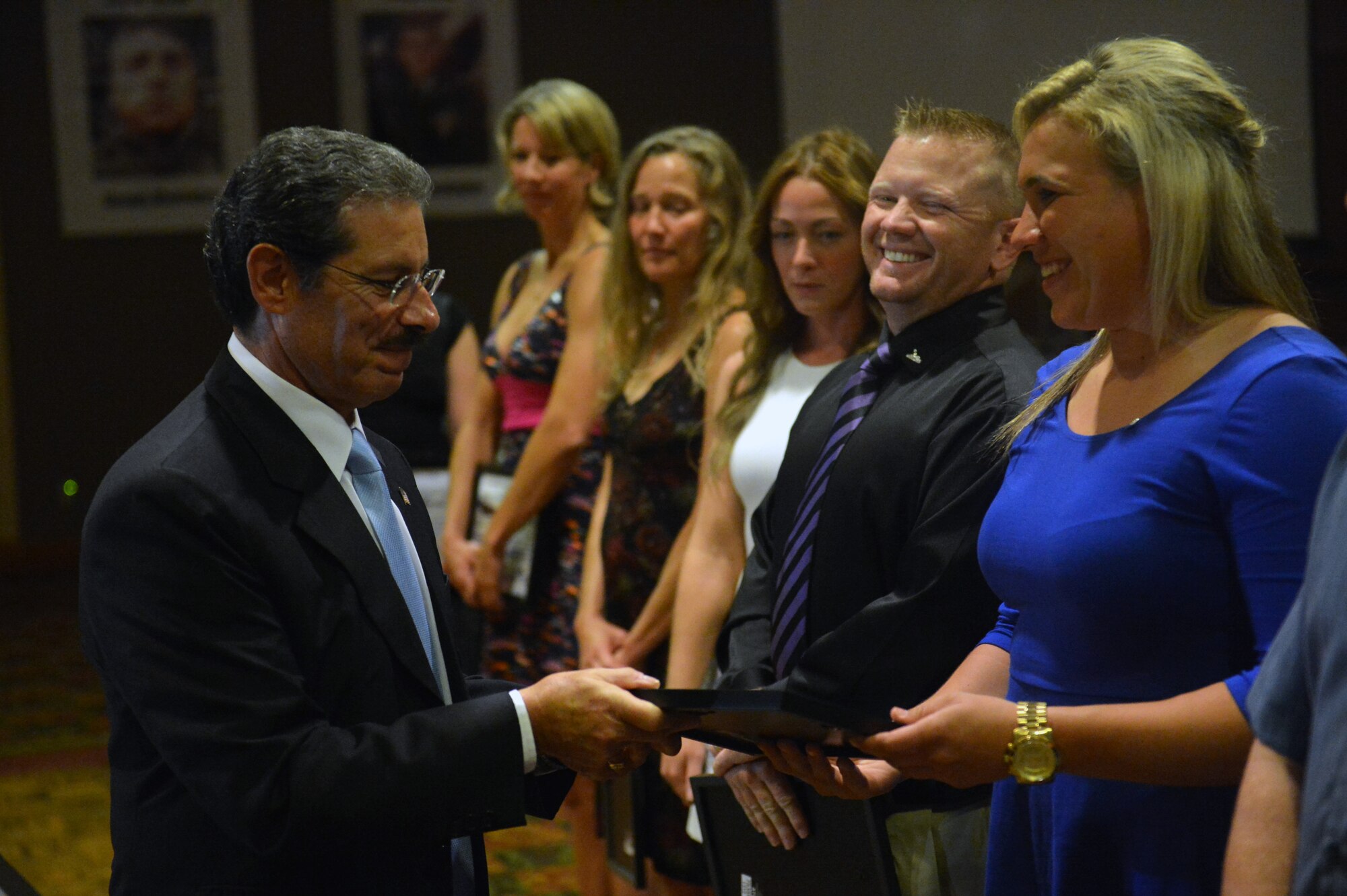 Pete Kremen, Whatcom County councilmember, presents 2nd Lt. Elizabeth Keenan, 62nd Comptroller Squadron flight commander a certificate of appreciation Aug. 25, 2014, for volunteering to swim in the Bellingham Bay to raise awareness for victims of post-traumatic stress during the Swim to Live banquet at Bellingham, Wash. The Bellingham Bay swim was followed by a banquet where the swimmers were honored after different speakers spoke to the audience about post-traumatic stress. (U.S. Air Force photo/Staff Sgt. Russ Jackson)