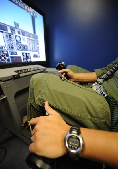 Capt. Richard Hansen, 9th Bomb Squadron pilot, sits at the controls of a simulator while connected to a reduced oxygen breathing device (ROBD) Aug. 8, 2014, at Dyess Air Force Base, Texas. The ROBD monitors a member’s oxygen level, while an aerospace physiologist controls the oxygen level to induce hypoxia symptoms during a recertification course. Airmen must be able to recognize the symptoms of hypoxia in order to maintain a safe flying environment while conducting missions. (U.S. Air Force photo by Airman 1st Class Kylsee Wisseman/Released)