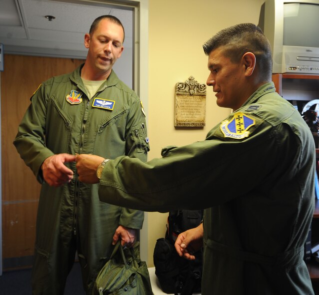 U.S. Air Force Capt. Tom Metzger, left, 7th Operations Group, receives his recertification card from Capt. Ezekiel Duran, 7th Aerospace Medicine Squadron aerospace physiologist, Aug. 8, 2014, at Dyess Air Force Base, Texas. Aircrew members go through refresher training every five years, mandated by Air Force Instruction 11-403, Aerospace Physiological Training Program, to ensure they are aware of physical threats associated with aviation challenges such as acceleration, ejection, spatial disorientation and hypoxia. (U.S. Air Force photo by Airman 1st Class Kylsee Wisseman/Released) 