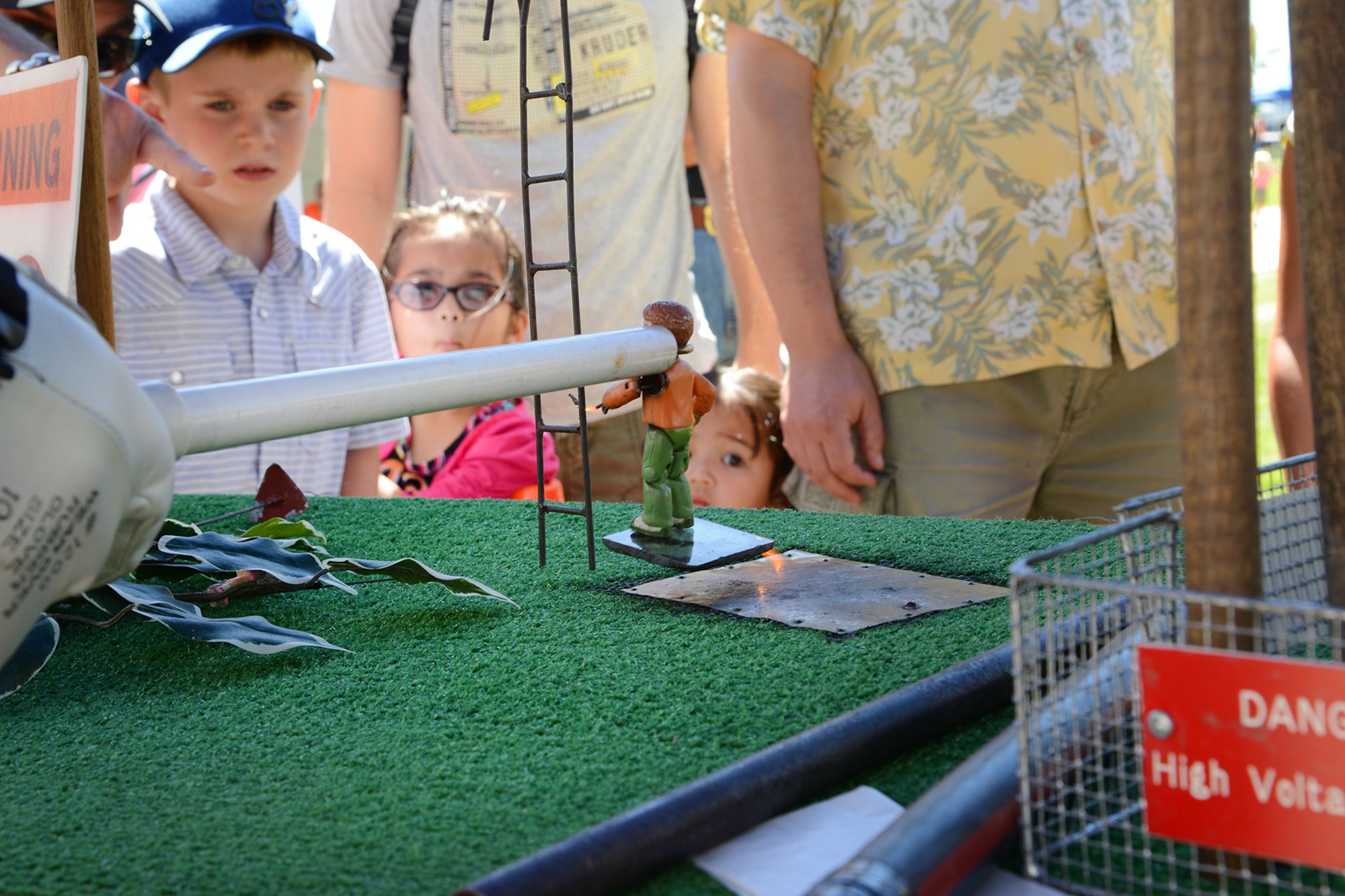 PETERSON AIR FORCE BASE, Colo. – Attendees learn about electric power line dangers from volunteers at the Colorado Springs Utilities booth during STEM Rocks! at the Peterson Air and Space Museum Aug. 23. The volunteers wanted children and parents alike to practice safety near power lines as the human body is an excellent conductor of electricity. Children and parents could visit nearly 30 booths to learn about Science, Technology, Engineering and Math in a fun, carnival-like environment. (U.S. Air Force photo/Tech. Sgt. Jared Marquis)