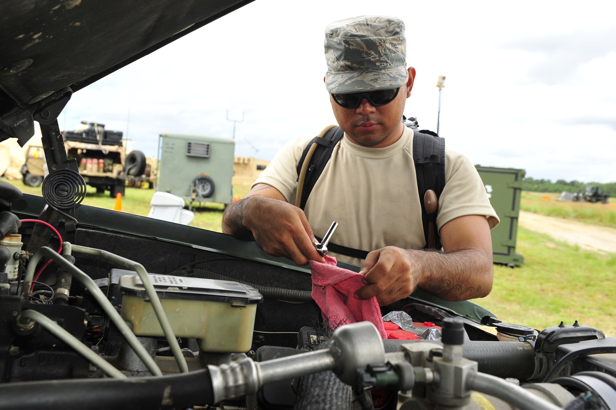JOINT BASE MCGUIRE-DIX-LAKEHURST, N.J. –Senior Airman Christopher Good, 818th Global Mobility Readiness Squadron vehicle maintainer, works on a battery in a vehicle during Eagle Flag 14-3, here, at the Lakehurst Naval Air Station, Aug. 11, 2014. The two-week long exercise that tested their ability to work along-side each other as a Joint Task Force-Port Opening (JTF-PO) team. The JTF-PO specializes in establishing hubs for cargo distribution operations worldwide, to include remote or damaged locations, on short notice. (U.S. Air Force photo by Staff Sgt. Gustavo Gonzalez)