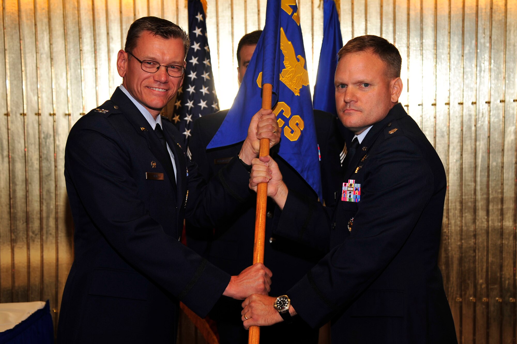 PETERSON AIR FORCE BASE, Colo. – Col. Reginald Ash (left), 21st Mission Support Group commander, passes the 21st Communications Squadron guidon to Lt. Col. John Heidenreich, incoming 21st CS commander, during an assumption of command ceremony Aug.18 at the Club. The 21st CS provides operations, maintenance, programming and implementation of command, control, communications and computer systems at Peterson AFB. (U.S. Air Force photo/Robb Lingley)