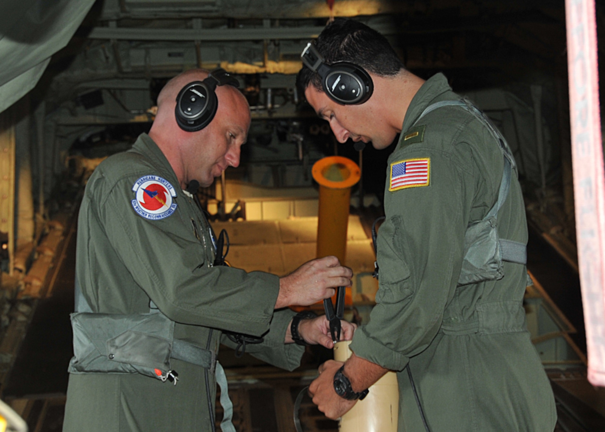 Tech. Sgt. Zachary Zieman, 53rd Weather Reconnaissance Squadron loadmaster and dropsonde operator, and U.S. Navy Ensign Zach Cornelius, U.S. Naval Academy Training and Research in Oceanic and Atmospheric Processes in Tropical Cyclones internship program, prepare an Airborne/Air Expendable Bathythermograph, or AXBT, deepwater bouy. The bouy was dropped during a 96L, now Hurricane Cristobal, invest mission over the Caribbean Aug. 23, 2014. The bouys are launched out of a launch tube in the back of the WC-130J. The bouys radio back information about ocean surface temperatures to depths of 800 to 1,000 feet. (U.S. Air Force photo/Maj. Marnee A.C. Losurdo)