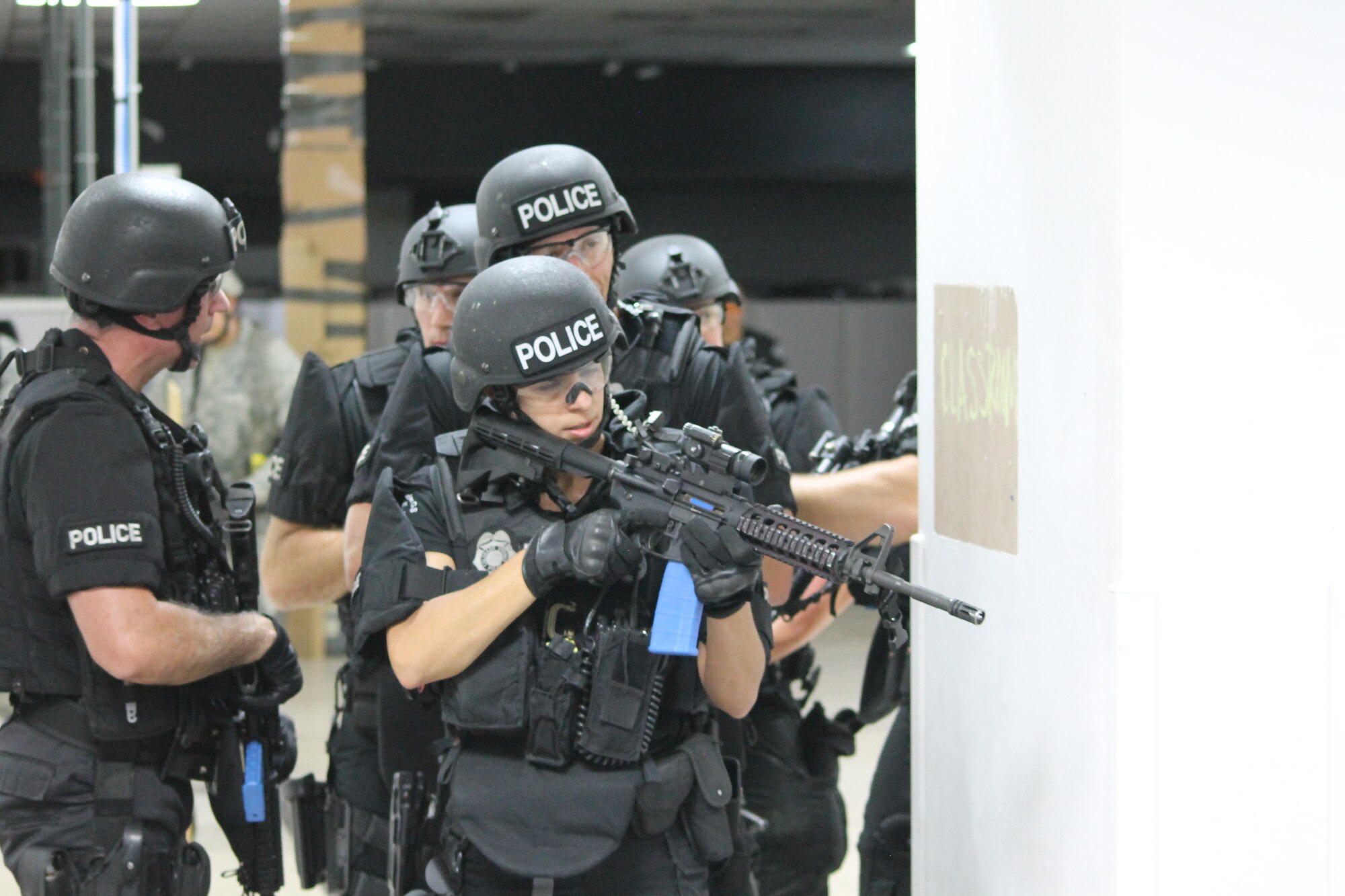 PETERSON AIR FORCE BASE, Colo. — Members of the Colorado Spring Police Department SWAT unit prepare to move forward and confront a lone-hostage taker who had just “killed” two Airmen, all part of a simulated active shooter and hostage scenario during this month’s Condor Crest exercise. The SWAT team was brought in to the exercise to provide hands-on experience coordinating with local law enforcement during a crisis event. Condor Crest is a quarterly exercise designed to test and evaluate base readiness for real-word events. (U.S. Air Force photo/Michael Golembesky)