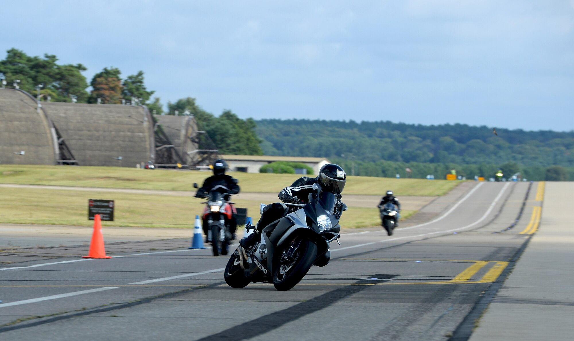 Motorcyclists ride through a closed course on the flightline during a motorcycle cornering event at Royal Air Force Lakenheath, Aug. 22, 2014. The cornering event was held to sharpen riders’ motorcycling skills to help riders become more familiar with their motorcycle’s capabilities and practice on roads similar to the surrounding area. (U.S. Air Force Photo by Staff Sgt. Emerson Nuñez/Released)