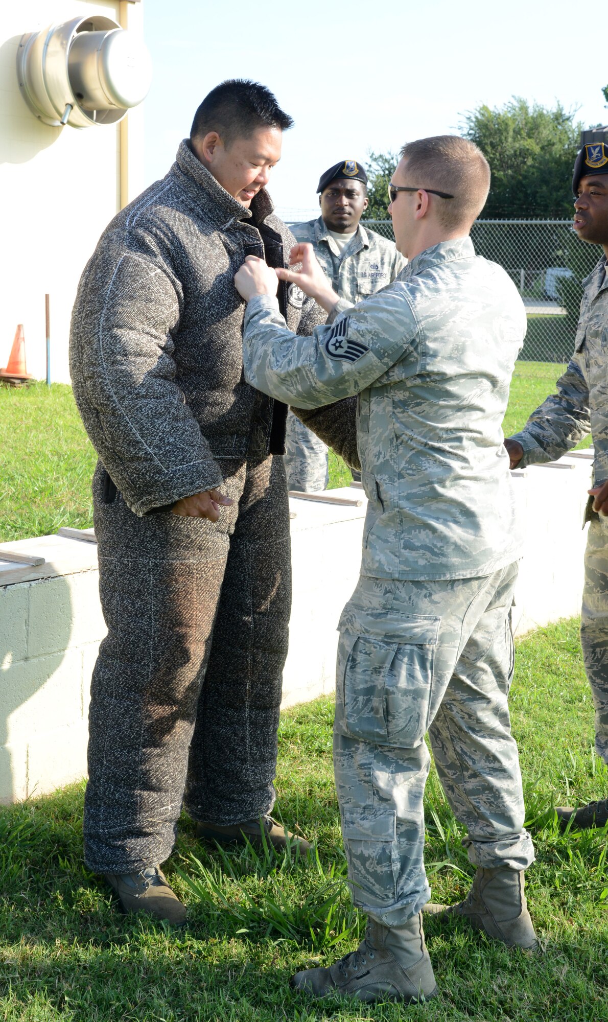 Assisted by members of the 72nd Security Forces Squadron, Lt. Col. Gerald Yap, 72nd Mission Support Group deputy commander, gears up in a bite suit for his Military Working Dog demonstration. (Air Force photo by Kelly White)