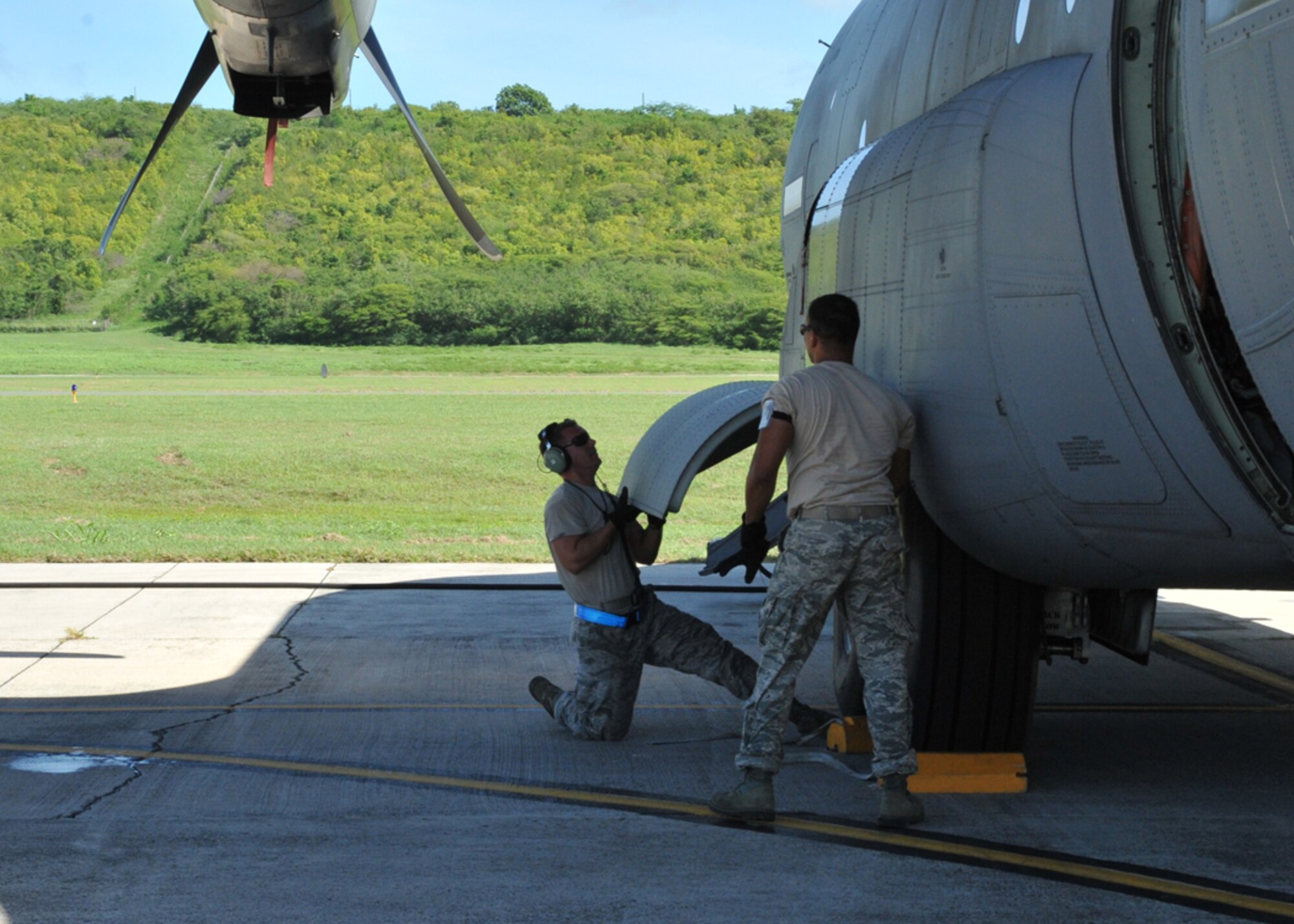 Staff Sgt. Rickey Carroll, 403rd Maintenance Squadron hydraulics specialist, and Senior Airman Earnest Naquin, 403rd MXS crewchief, perform an hydraulics inspection on the landing gear of a WC-130J at the Henry E. Rohlsen Airport in St. Croix, U.S. Virgin Islands Aug. 25, 2014. The maintainers are deployed from Keesler Air Force Base, Mississippi, to St. Croix to assist the 53rd Weather Reconnaissance Squadron, which has been flying storm missions into Hurricane Cristobal since Aug. 21, 2014. (U.S. Air Force photo/Maj. Marnee A.C. Losurdo)