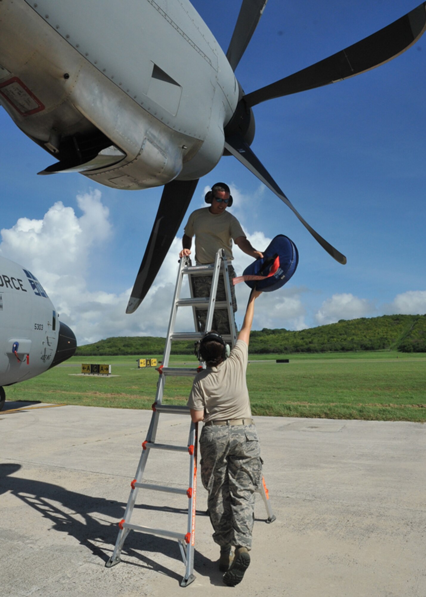 Staff Sgt. Crystal Pourciau hands Tech. Sgt. Daryl Weeks a plug to install into the engine intake at the Henry E. Rohlsen Airport in St. Croix, U.S. Virgin Islands Aug. 25, 2014. Pourciau and Weeks work in the 403rd Maintenance Squadron at Keesler Air Force Base, Mississippi. They are deployed to St. Croix to assist the 53rd Weather Reconnaissance Squadron, which has been flying storm missions into Cristobal since Aug. 21, 2014. (U.S. Air Force photo/Maj. Marnee A.C. Losurdo)