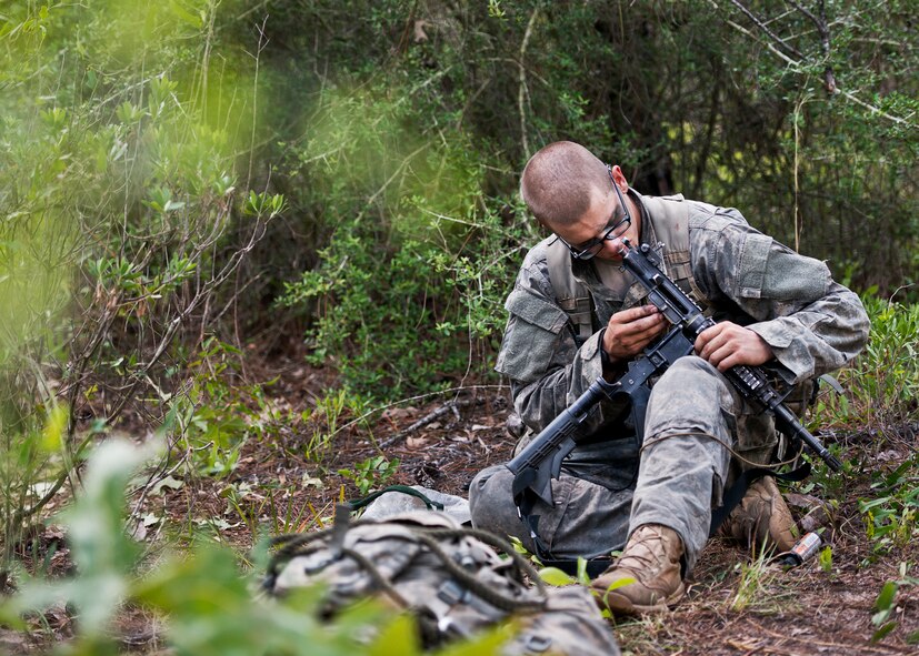 An Army Ranger student cleans his weapon prior during some down time in the woods of the Eglin Air Force Base, Fla., range.  Students complete the final phase of the Army Ranger course with the 6th Ranger Training Battalion.  Instructors expose the students to 18-day field training that includes airborne and helicopter assaults, small boat operations, river and swamp crossings.  (U.S. Air Force photo/Tech. Sgt. Samuel King Jr.)