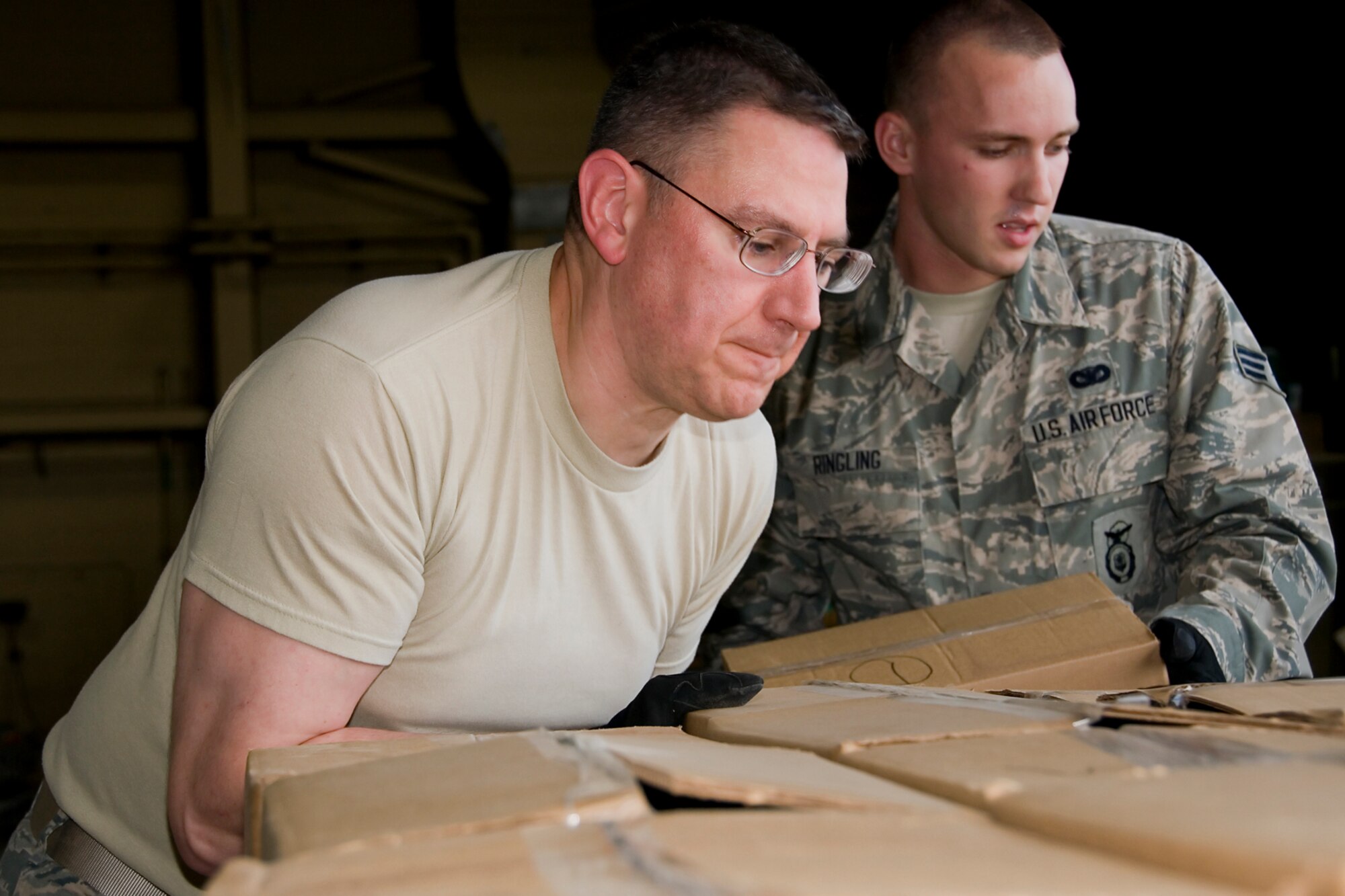 Tech. Sgt.  Joseph Schluttenhofer, 434th Air Refueling Wing pay technician, and Senior Airman Andrew Ringling, 434th Security Forces Squadron fire team member, stack boxes on one of many pallets to be shipped aboard a KC-10 Extender aircraft at Grissom Air Reserve Base, Ind., Aug 9, 2014. Grissom Air Force reservists teamed up with Airmen from Charleston Air Force Base, S.C., to deliver 91,000 pounds of food, clothes and supplies to Haiti as part of a humanitarian relief mission under the Denton Program. (U.S. Air Force photo/Senior Airman Jami K. Lancette)