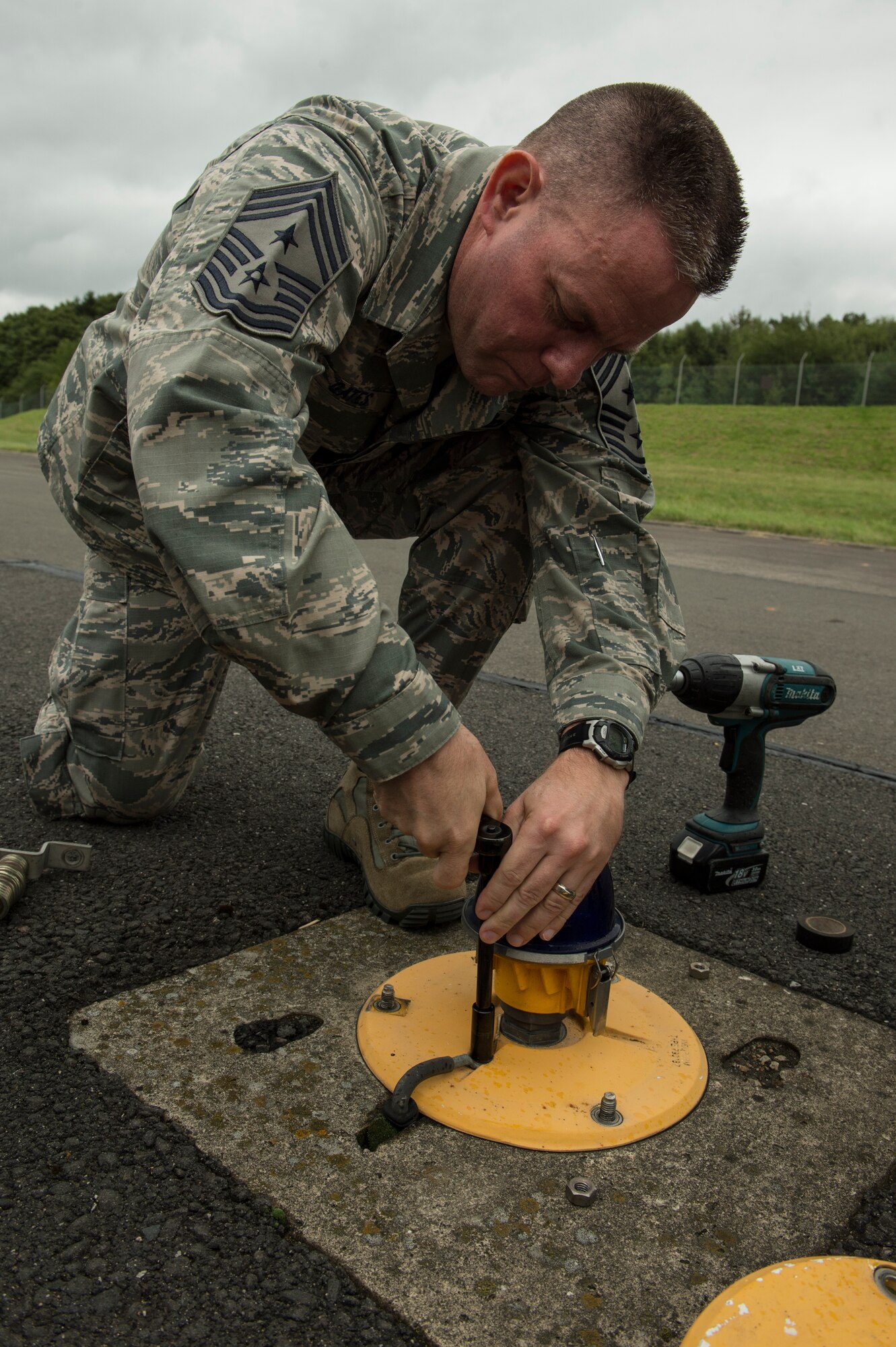 U.S. Air Force Chief Master Sgt. Brian Gates, 52nd Fighter Wing command chief, upgrades a taxiway light with an Light-Emitting Diode Aug. 26, 2014, at Spangdahlem Air Base, Germany. The 52nd Civil Engineer Squadron invited Gates and U.S. Air Force Col. Pete Bilodeau, 52nd FW commander, to experience their job first-hand.  (U.S. Air Force photo by Staff Sgt. Christopher Ruano/Released)