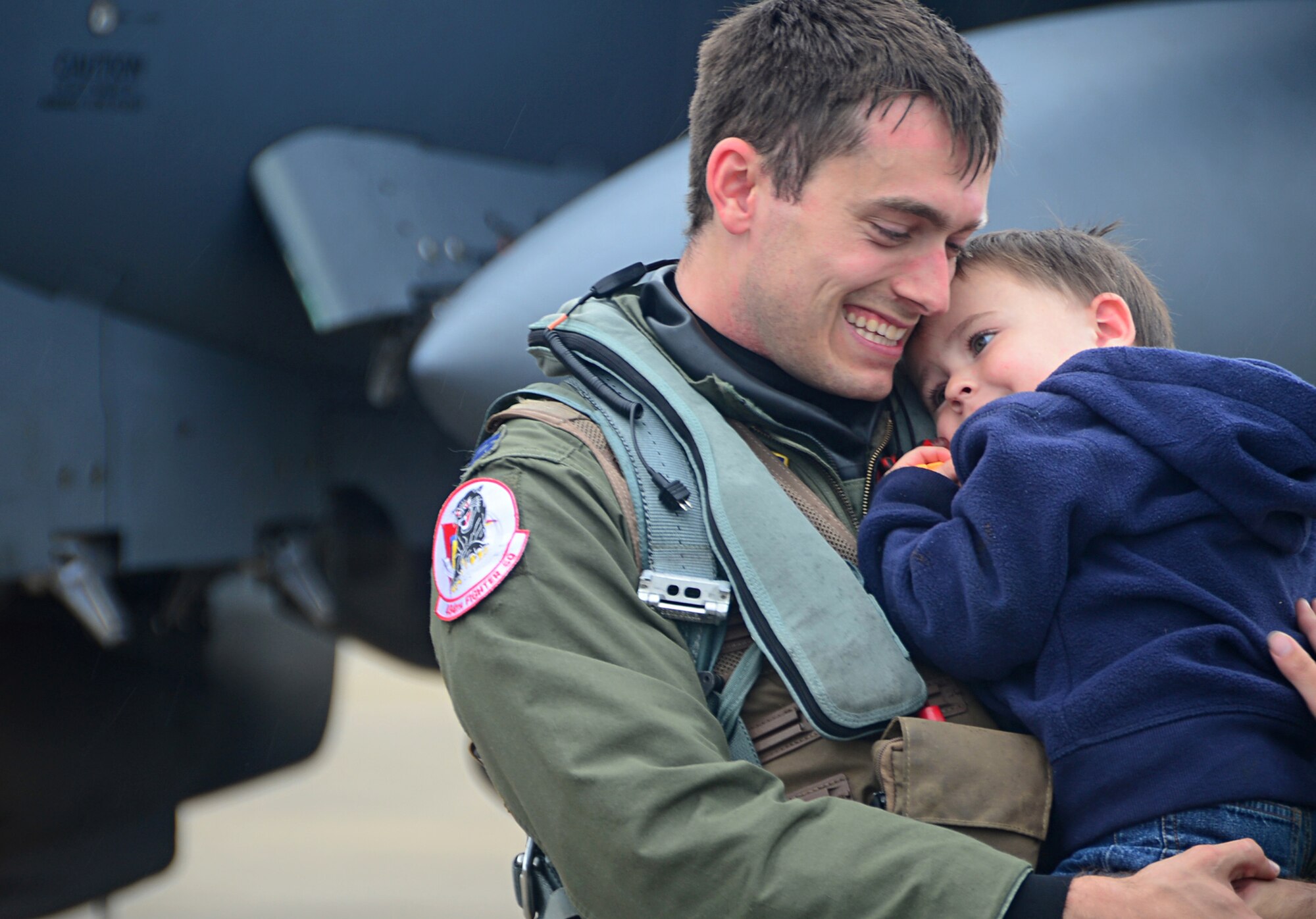 Capt. Erik Hulme, 494th Fighter Squadron F-15E Strike Eagle fighter pilot, hugs his son on the flightline at Royal Air Force Lakenheath, England, Aug. 25, 2014, after returning from  exercises in the U.S. Red Flag is an advanced training program and provides participants with valuable training in planning and executing a wide-variety of combat missions. (U.S. Air Force photo by Airman 1st Class Erin O’Shea/Released) 