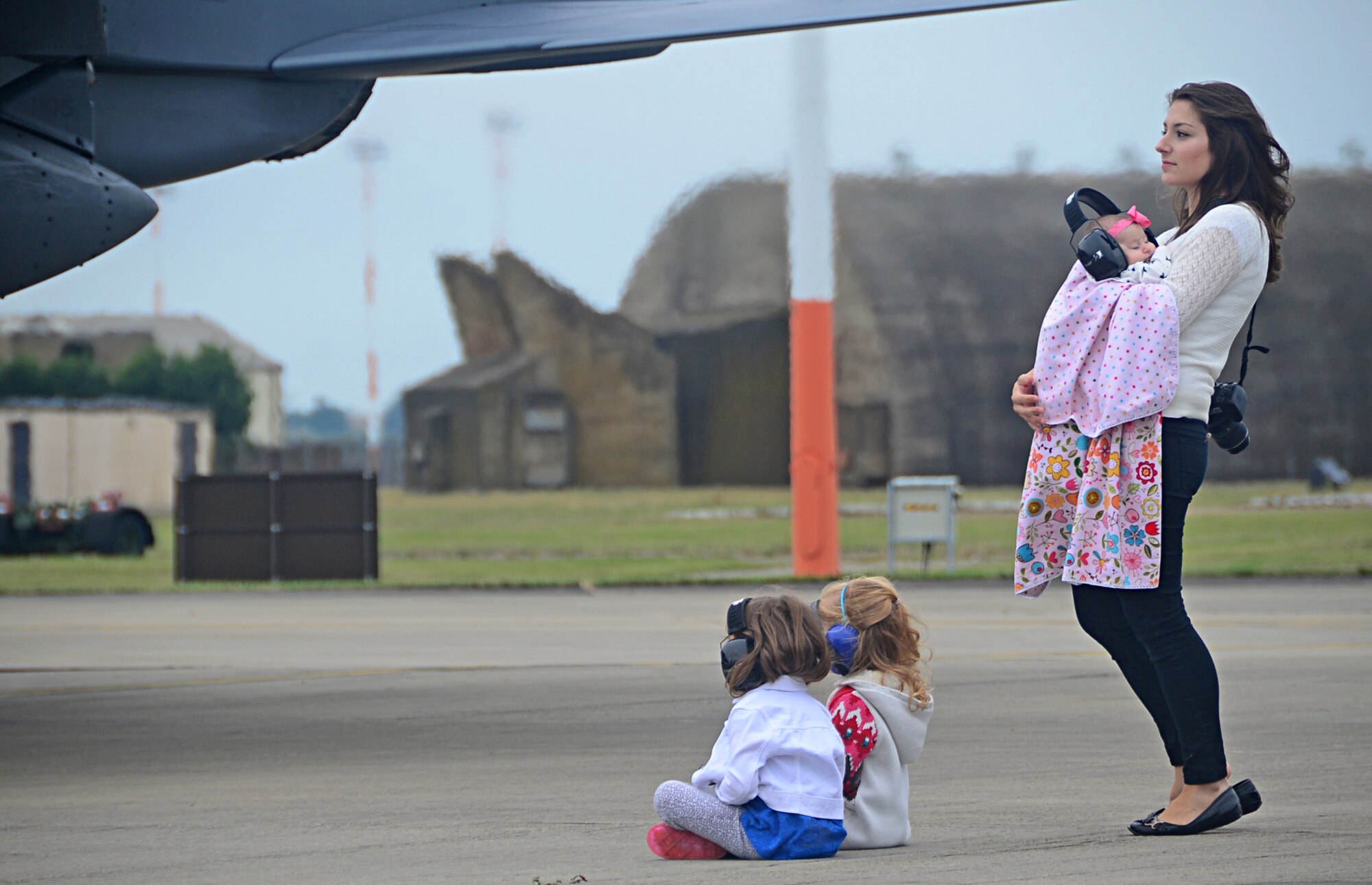 The family of Capt. Matthew Gardner, 494th Fighter Squadron F-15E Strike Eagle fighter pilot, waits for the squadron’s arrival on the flightline at Royal Air Force Lakenheath, England, Aug. 25, 2014. The 48th Fighter Wing aircraft returned after participating in Red Flag exercise 14N-3 at Nellis Air Force Base, Nev., and the Combat Hammer and Combat Archer exercises at Hill Air Force Base, Utah. (U.S. Air Force photo by Airman 1st Class Erin O’Shea/Released) 