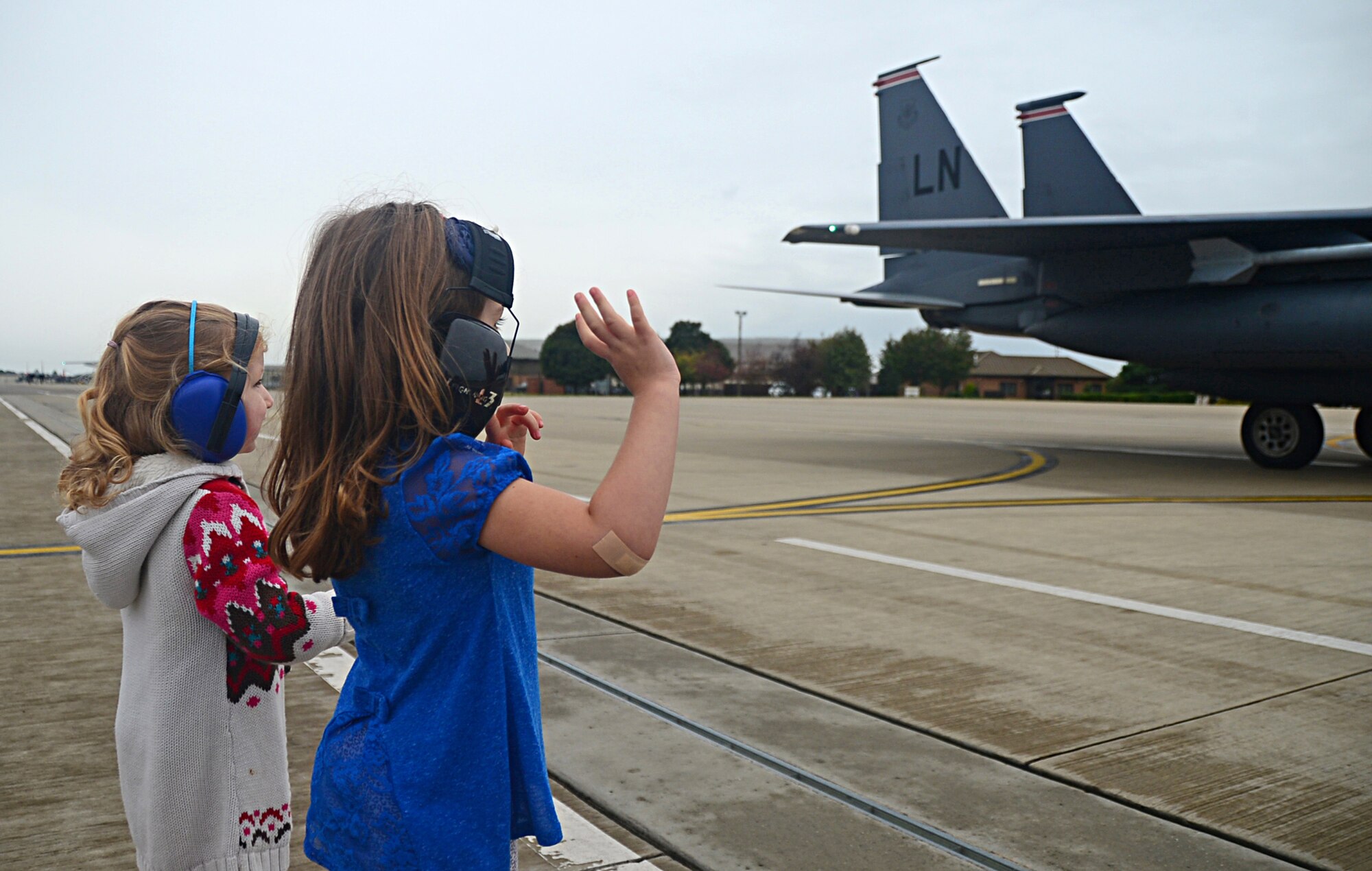 Children wave to 494th Fighter Squadron F-15E Strike Eagle fighter pilots as they arrive at Royal Air Force Lakenheath, England, Aug. 25, 2014, from exercises in the U.S. The 48th Fighter Wing aircraft returned after participating in Red Flag exercise 14N-3 at Nellis Air Force Base, Nev., and Combat Hammer and Combat Archer exercises at Hill Air Force Base, Utah. (U.S. Air Force photo by Airman 1st Class Erin O’Shea/Released) 