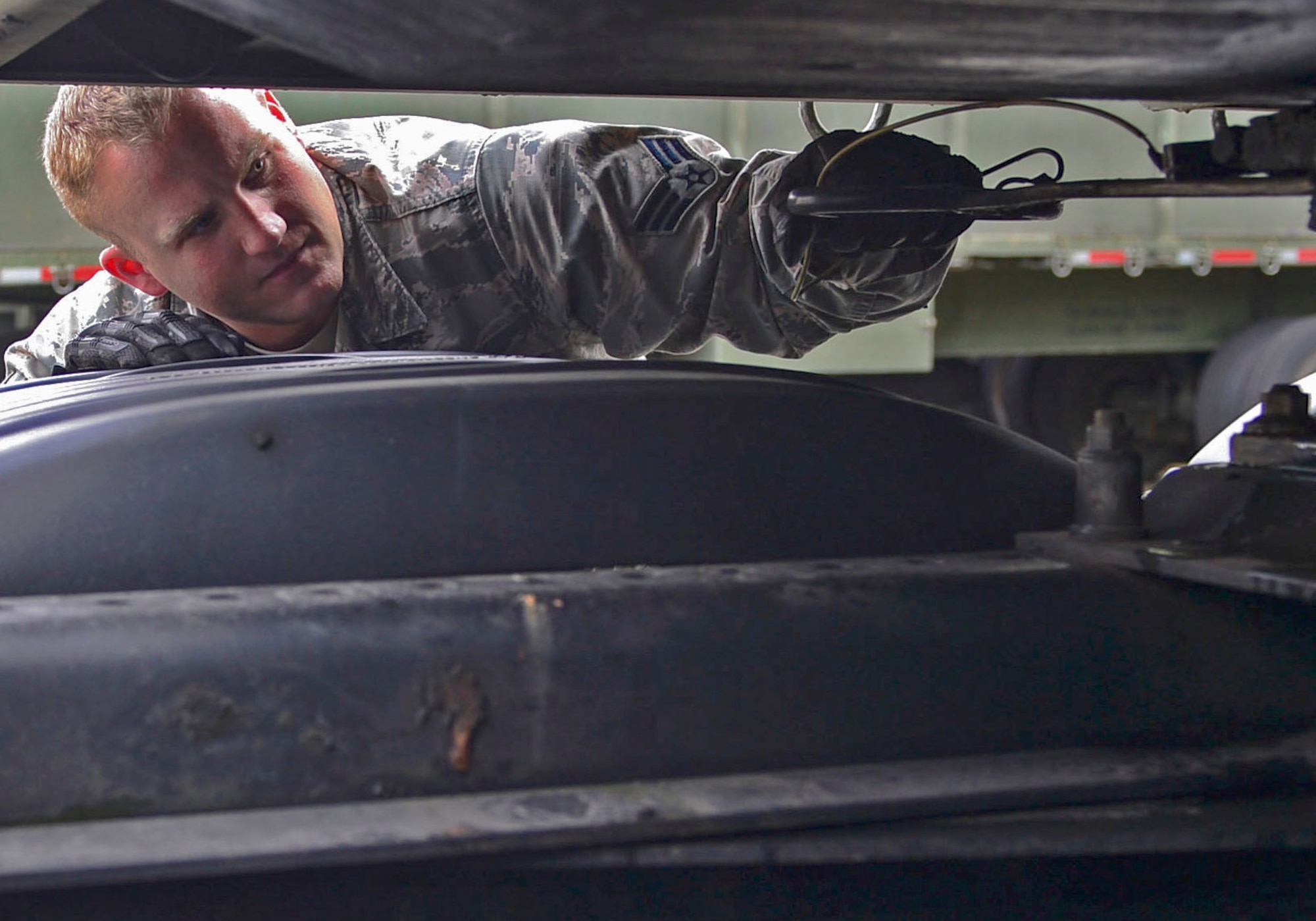 Senior Airman Troy Rehmert, 48th Logistics Readiness Squadron vehicle operations control dispatcher, inspects a trailer at Royal Air Force Lakenheath, England, Aug. 26, 2014. Rehmert was nominated for a Liberty Spotlight because he displays the core value of Service Before Self. (U.S. Air Force photo by Airman 1st Class Dawn M. Weber/Released)