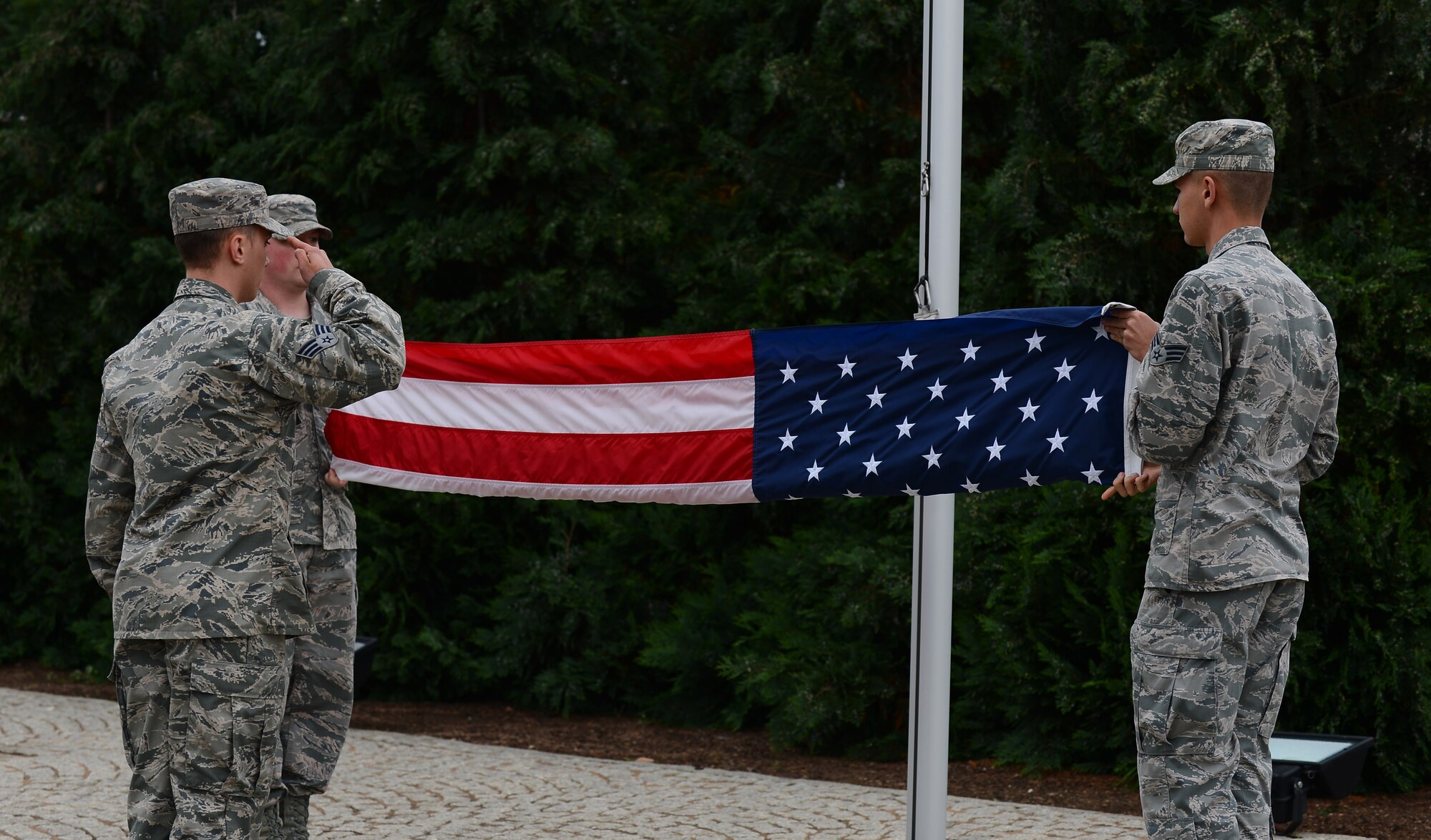 Spangdahlem Air Base Honor Guard members fold the U.S. flag during a retreat ceremony at Spangdahlem Air Base, Germany, Aug. 25, 2014.  The honor guard performs the flag-folding ceremony at retirements, funerals and other special events. (U.S. Air Force photo by Airman 1st Class Luke J. Kitterman/Released)