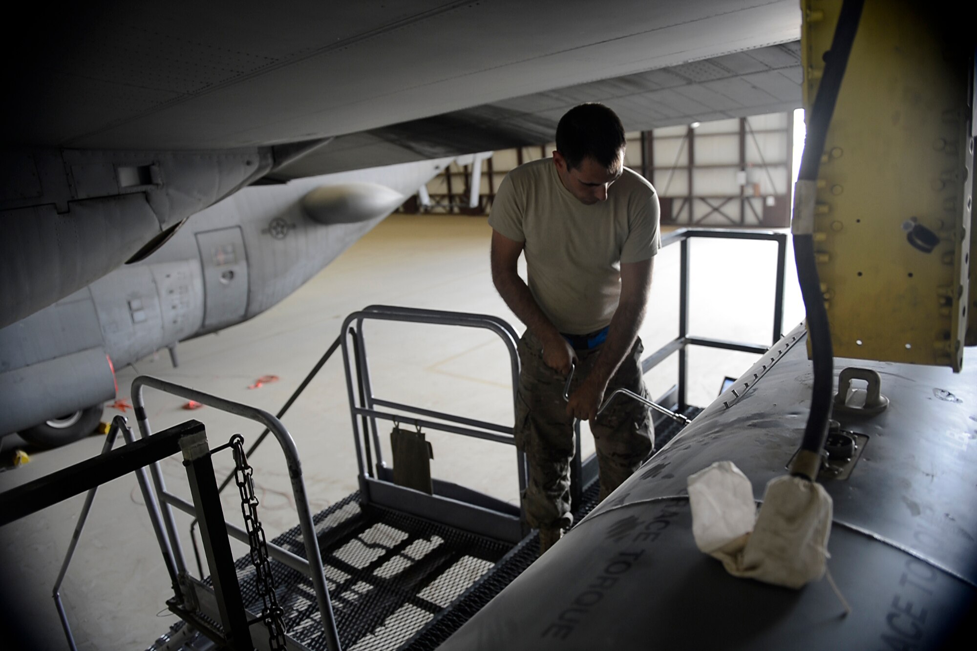 U.S. Air Force Senior Airman Jason Panian, 41st Expeditionary Electronic Combat Squadron electronic warfare systems journeyman, performs maintenance on an EC-130H Compass Call aircraft at Bagram Airfield, Afghanistan Aug. 25, 2014.  The 41st EECS conducts communications jamming with the EC-130H in support of Operation Enduring Freedom. Panian is deployed from Davis-Monthan Air Force Base, Ariz. and a native of Portland, Ore. (U.S. Air Force photo by Staff Sgt. Evelyn Chavez/Released)