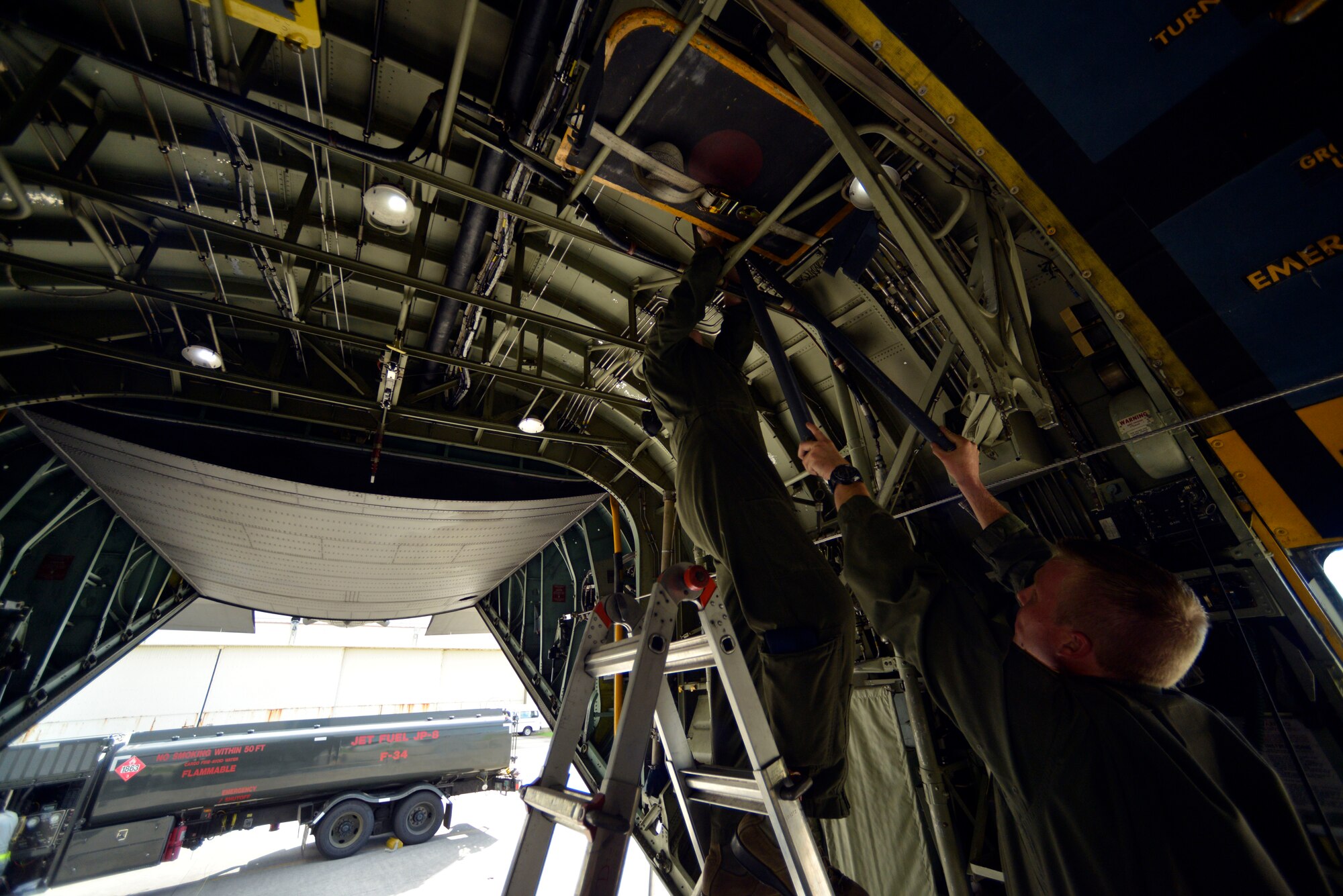 Loadmasters from the 36th Airlift Squadron at Yokota Air Base, Japan, prepare a C-130 Hercules for static line jumping on Aug. 25, 2014.  Yokota Airmen trained alongside members of the 31st Rescue Squadron at Kadena Air Base, Okinawa, to stay current on deployment requirements and upgrade training.  (U.S. Air Force photo by Tech. Sgt. Melissa Mekpongsatorn/released)