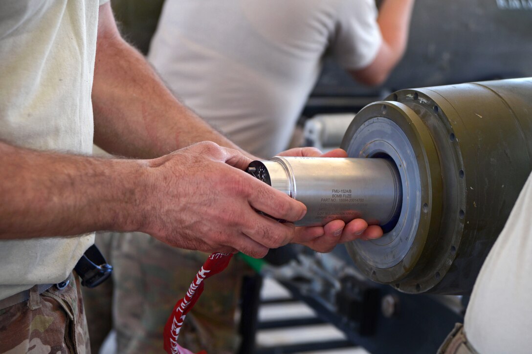 A U.S. airman installs an FMU-152 tail fuse into the end of a GBU-38 bomb on Bagram Airfield, Afghanistan, Aug. 14, 2014. 