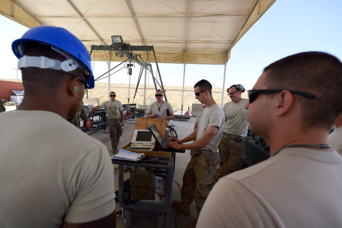 U.S. airmen gather to review safety procedures before building 10 GBU-38 bombs on Bagram Airfield, Afghanistan, Aug. 14, 2014. The GBU-38s are part of the weapon system used on F-16C Fighting Falcon aircraft. The airmen are munitions systems technicians assigned to the 455th Expeditionary Maintenance Squadron. 