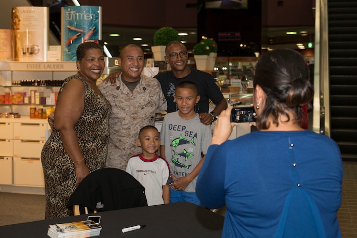 Tommy Davidson and Miss Gayle, entertainers with Kenny Hill’s All Star Comedy Slam pose with Gunnery Sgt. Denver Inopiquez and his sons inside the Marine Corps Exchange aboard Marine Corps Air Station Iwakuni, Japan, Aug. 27, 2014. As part of the comedy slam, Davidson and Gayle Davidson are slated to tour the air station, as well as performing a live comedy show inside Club Iwakuni.      
