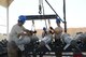Tech. Sgt. Patrick Williams (left) and Senior Airman Brandon Graves attach GBU-38 bombs to a hoist that will be used with a munitions assembly conveyer to move the bombs during transport Aug. 14, 2014, at Bagram Airfield in support of Operation Enduring Freedom.  Both men are currently assigned to the 455th Expeditionary Maintenance Squadron and both are reservists deployed from the 442nd Fighter Wing, Whiteman Air Force Base, Mo. (U.S. Air Force photo by Master Sgt. Cohen A. Young)