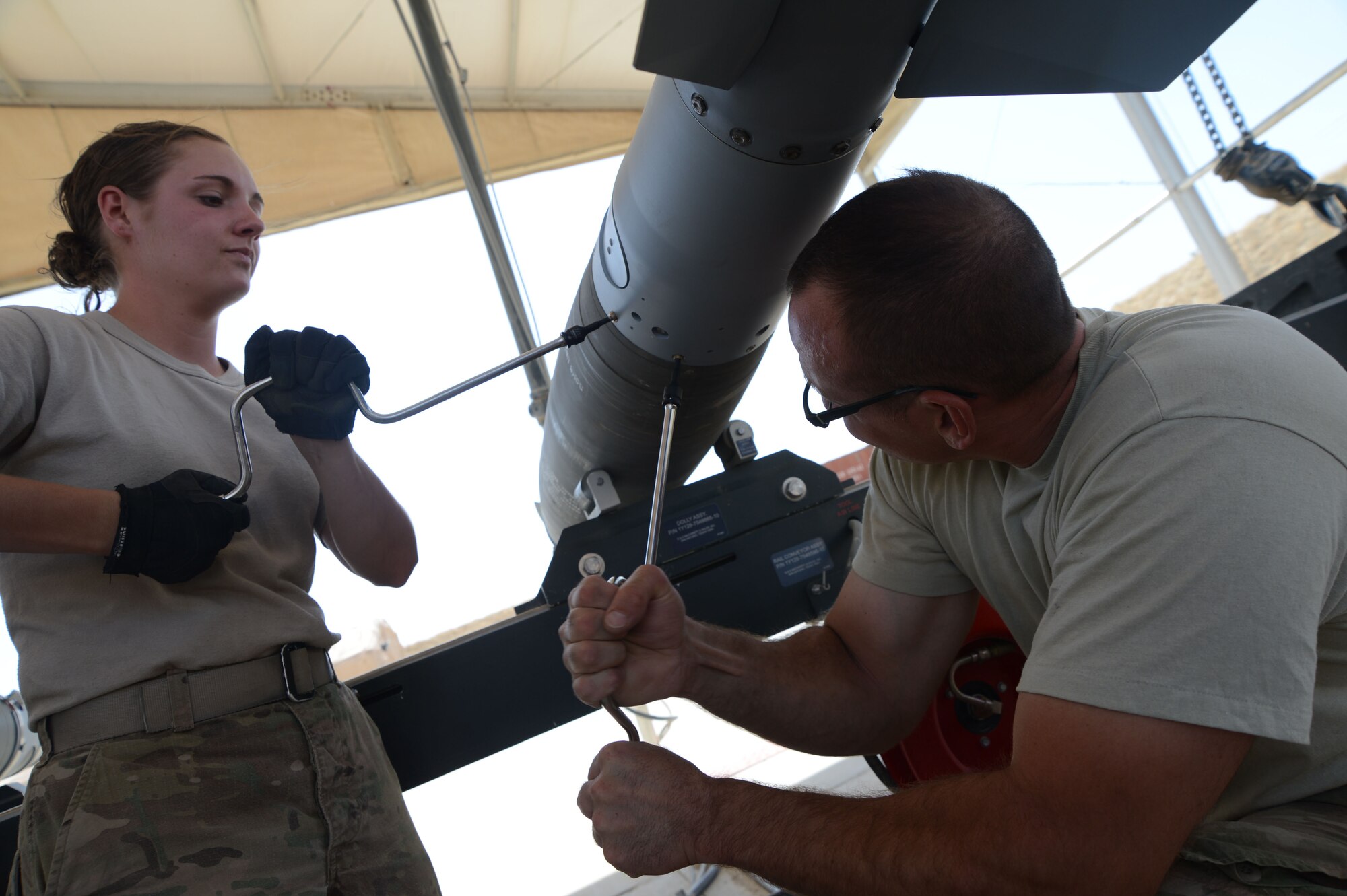 Airman 1st Class Casey Cain and Tech. Sgt. Patrick Williams tighten the screws on a GBU-38 during its construction while at Bagram Airfield, Afghanistan Aug. 14, 2014. The GBU-38 is a necessary part of the weapon system of the F-16C Fighting Falcon. Cain is a reservist  deployed from Whiteman Air Force Base, Mo. Williams is a reservist deployed from the 442nd Fighter Wing in Missouri. (U.S. Air Force photo by Master Sgt. Cohen A. Young)