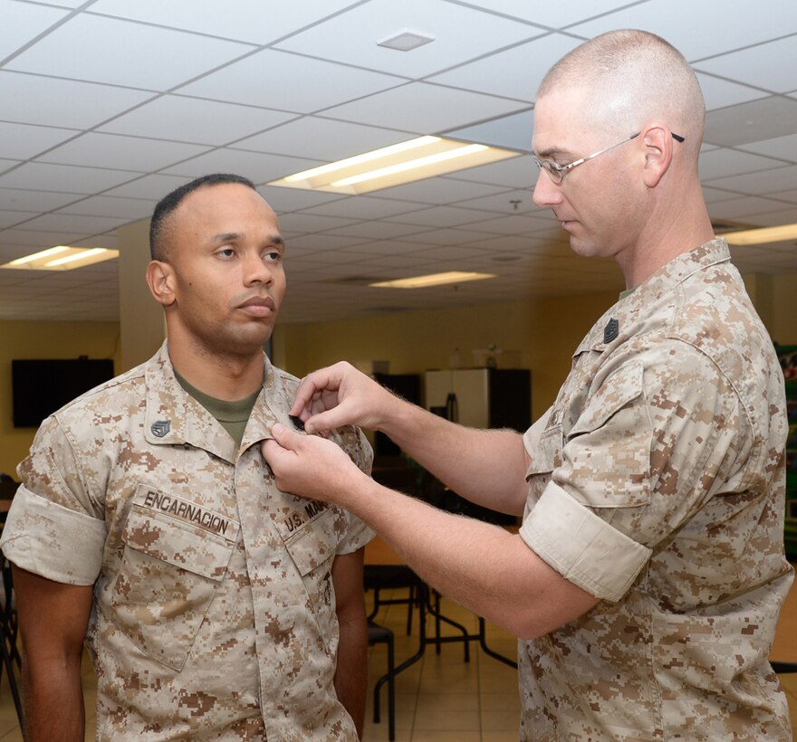 Staff Sgt. Johnnie M. Encarnacion, procurement specialist, Marine Corps Logistics Command, receives his new rank in a ceremony, here, recently. Master Sgt. William Tolleson, procurement chief, LOGCOM, pinned the newly-promoted staff sergeant. Tolleson characterized the new staff sergeant as very deserving and hard working, one who goes above and beyond, and one who far exceeds his expectations.