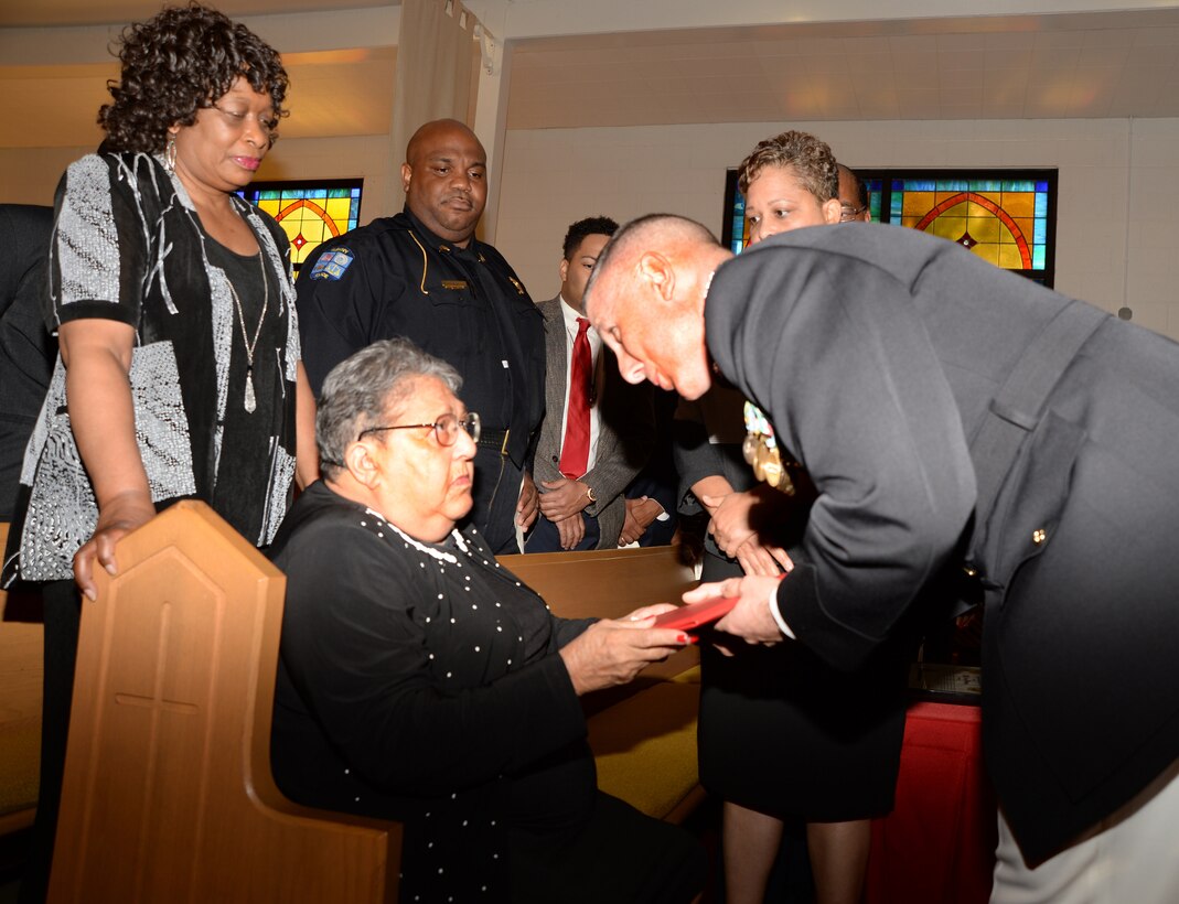 Carletha Windom accepts a proclamation honoring her late husband, Pfc. James Windom - an original Montford Point Marine - from Col. Don Davis, commanding officer, Marine Corps Logistics Base Albany, during a ceremony at the Chapel of the Good Shepherd, here, Aug. 22.