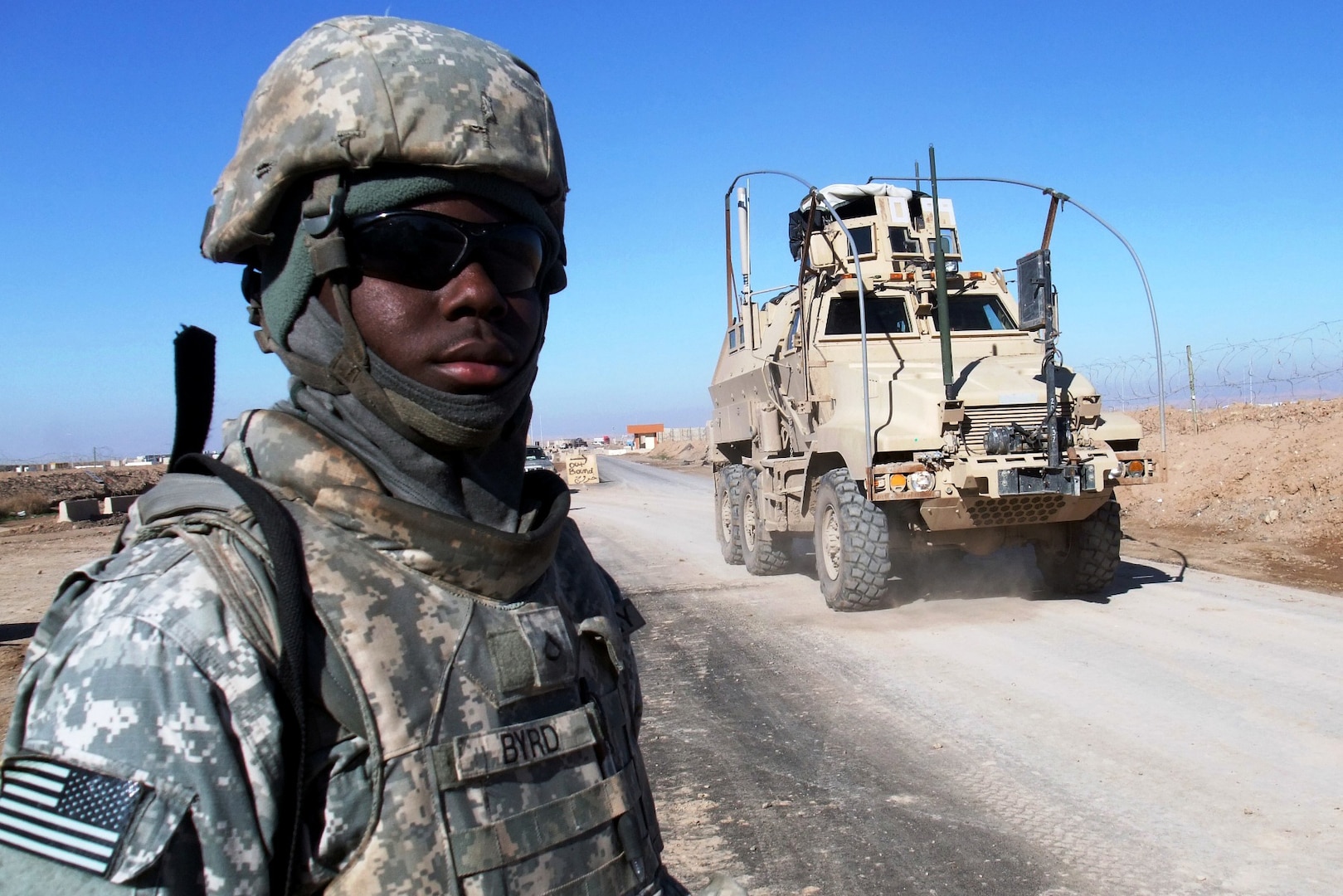 Master Pfc. Quintavis B. Byrd, a gate sentinel from the Mississippi National Guard, watches gun trucks pass the main entry control point of Contingency Operating Location Q-West, Jan. 10. Byrd serves with A Company, 2nd Battalion, 198th Combined Arms, 155th Brigade Combat Team, a mechanized infantry unit out of Hernando, Miss., that provides force protection to Q-West. This day marked the unit's sixth month of ECP operations. There have been no security breaches during their tenure.
