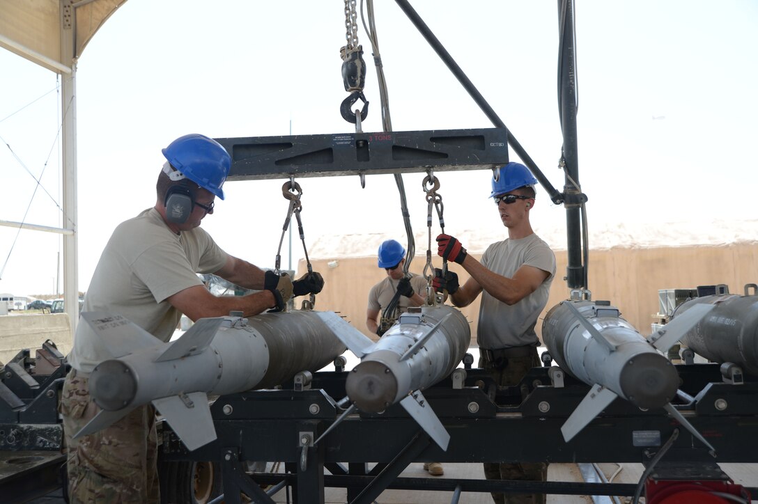 Tech. Sgt. Patrick Williams and Senior Airman Brandon Graves attach GBU-38 bombs to a hoist that will be used with a munitions assembly conveyer to move the bombs during transport Aug. 14, 2014, at Bagram Airfield in support of Operation Enduring Freedom. Both Airmen are assigned to the 455th Expeditionary Maintenance Squadron and both are reservists deployed from the 442nd Fighter Wing, Whiteman Air Force Base, Mo. (U.S. Air Force photo/Master Sgt. Cohen A. Young)