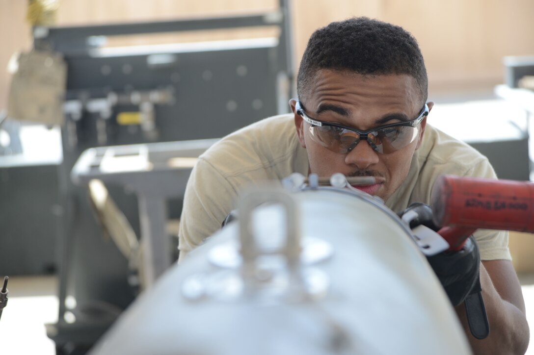 Airman 1st Class Tony Chatman aligns the front strike of the bomb lugs on a GBU-38 bomb Aug. 14, 2014, at Bagram Airfield, Afghanistan. The GBU-38 is the prime bomb utilized with the F-16C Fighting Falcon. Chatman is a munitions systems technician assigned to the 455th Expeditionary Maintenance Squadron and is a native of Atlantic City, N.J. (U.S. Air Force photo/Master Sgt. Cohen A. Young)
