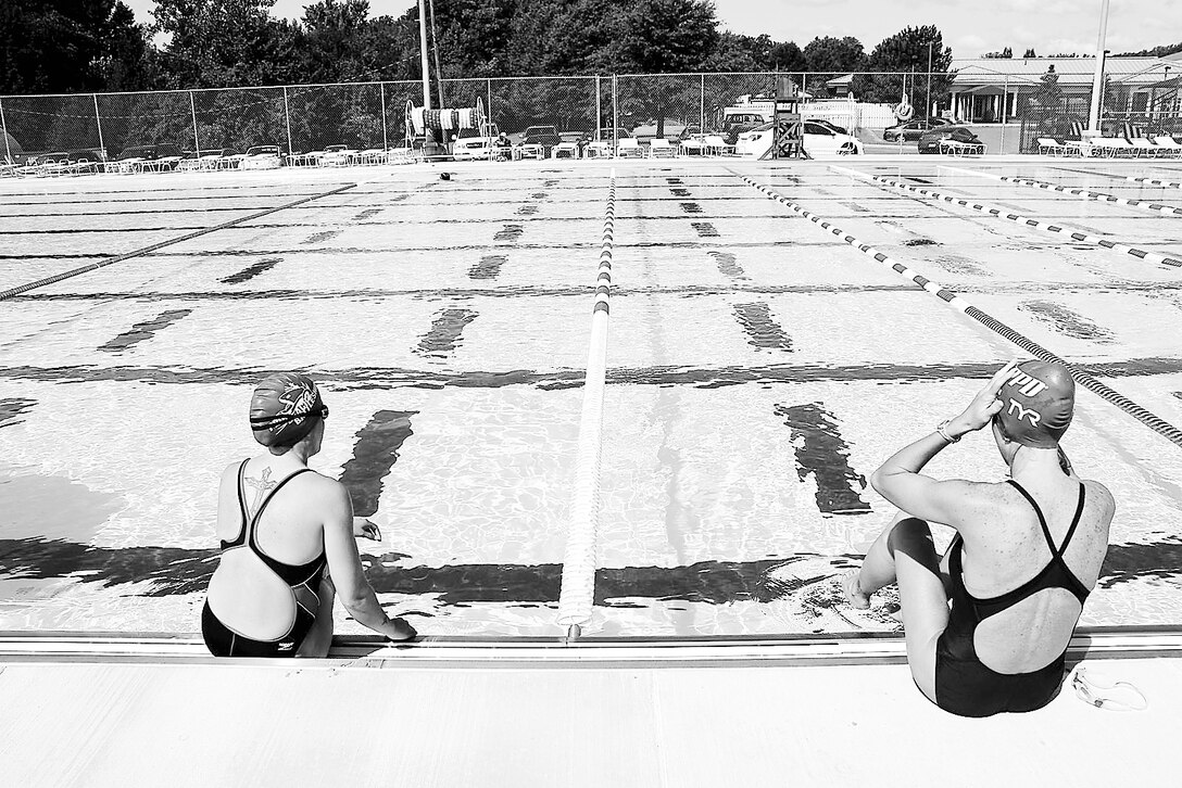 Patrons of Marine Corps Base Quantico’s 50M Pool sit on the pool’s edge before swimming laps Aug. 25.