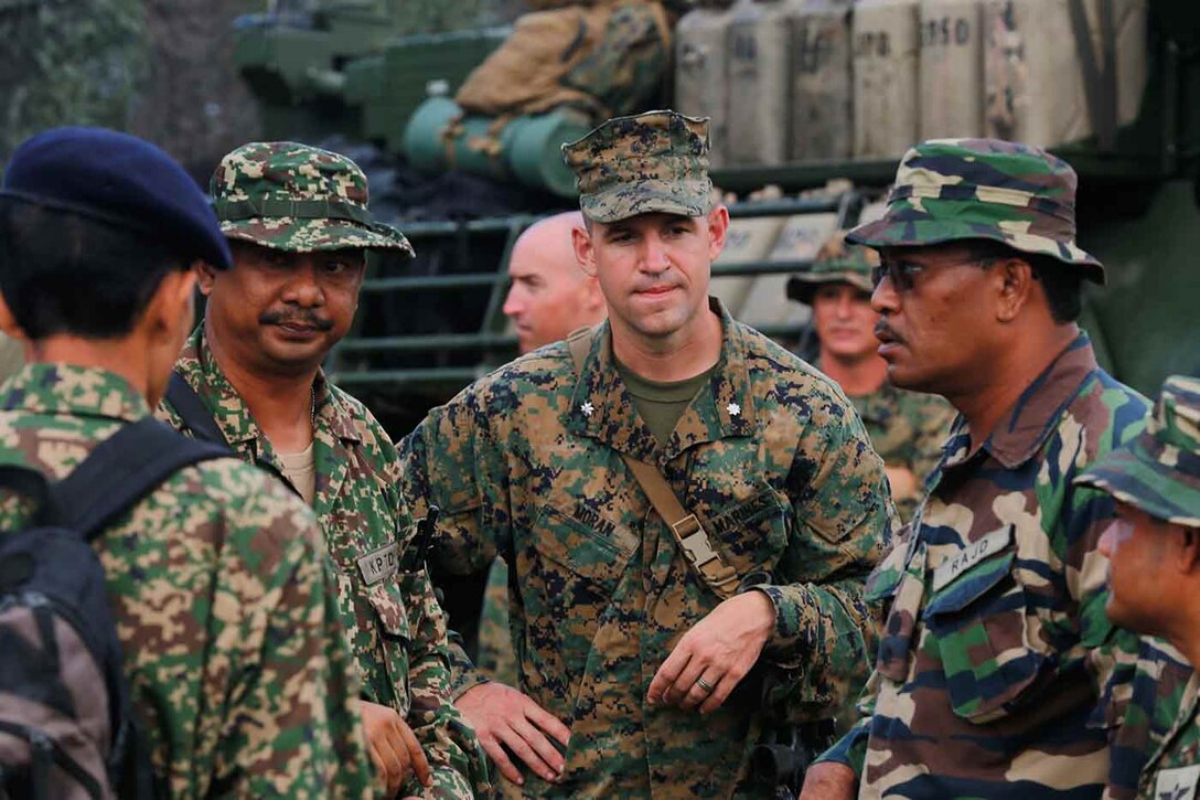 Lt. Col. Coby Moran, commanding officer of Battalion Landing Team 2nd Battalion 1st Marines, 11th Marine Expeditionary Unit listens as members of the Malaysian Armed Forces discuss amphibious operations during Malaysia-United States Amphibious Exercise 2014. MALUS AMPHEX 14 is a bilateral exercise between the 11th MEU and Malaysian Armed Forces designed to foster and sustain cooperative and international relationships with emphasis on amphibious and humanitarian operations within the context of a stability and security operation. (U.S. Marine Corps photo by Gunnery Sgt. Rome M. Lazarus/Released)