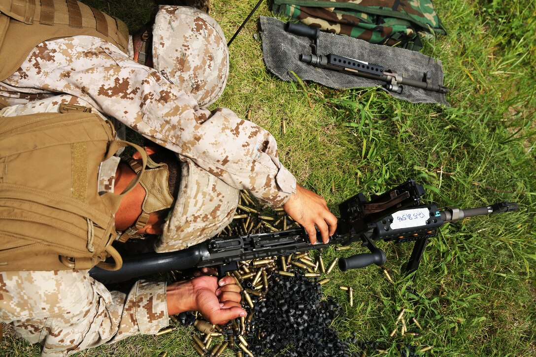 Lance Cpl. John Rueda, left, clears the chamber of a M-240B machine gun for Lance Cpl. Andy Jimenez during a live-fire range at Marine Corps Base Camp Lejeune, N.C., Aug. 25, 2014. Both Rueda and Jimenez are air support operations operators with Marine Air Support Squadron 1.