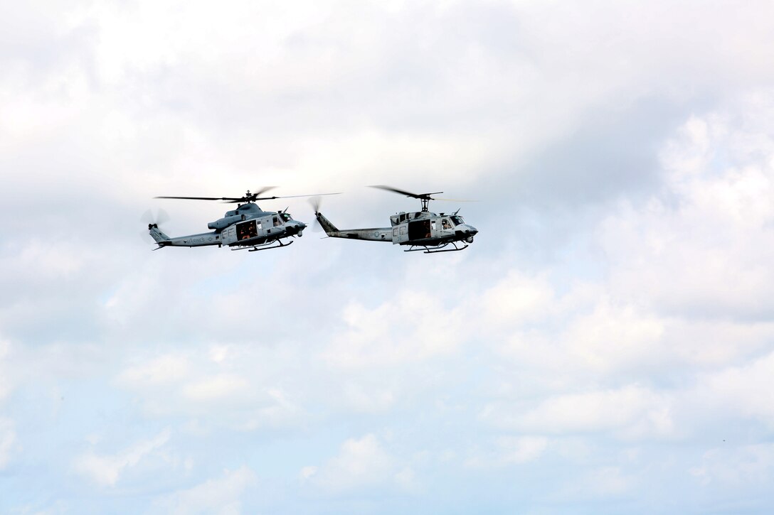 The UH-1N Huey (Right) escorts a UH-1Y Venom (Left) during the final flight of the UH-1N Huey for Marine Light Attack Helicopter Squadron 773, Marine Aircraft Group 49, aboard Naval Air Station Joint Reserve Base, New Orleans, Aug. 28, 2014. The escort symbolizes the stepping aside of one helicopter platform to allow for an improved version to takes its place.