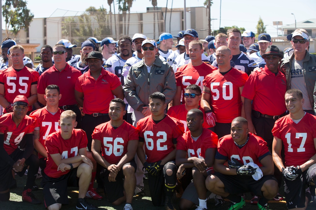 Members of the Marine Corps Air Station Miramar Falcons take a photo with the San Diego Chargers during a military appreciation day aboard MCAS Miramar, Calif., Aug. 27. The Chargers showed their support to Service members by engaging with fans and signing autographs after practice.  