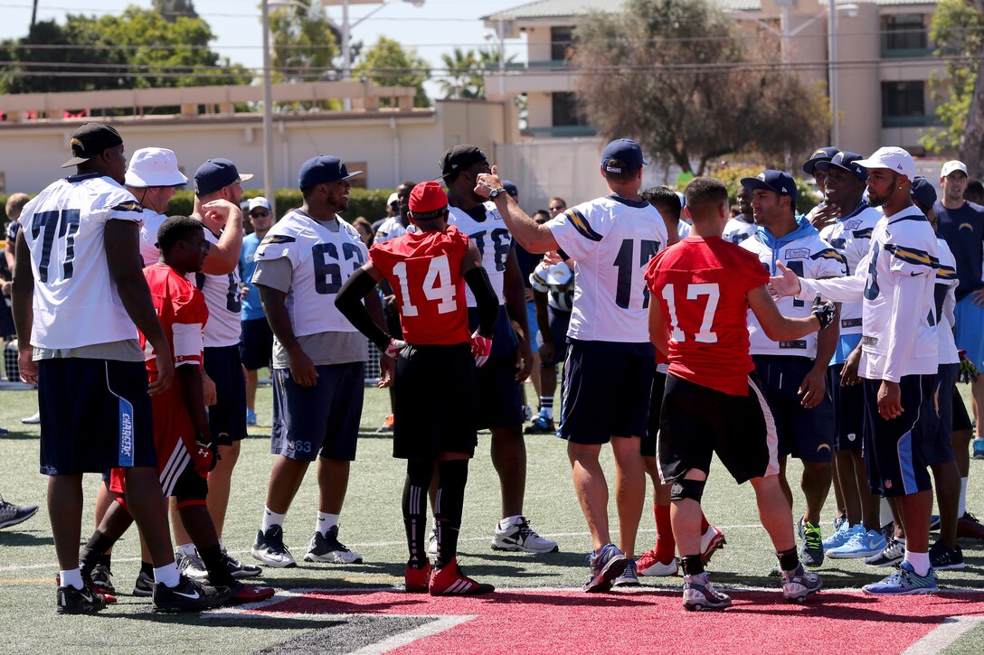 Members of the San Diego Chargers meet members of the Marine Corps Air Station Miramar Falcons during a military appreciation day aboard MCAS Miramar, Calif., Aug. 27. The Chargers signed autographs and socialized with fans after the practice. 