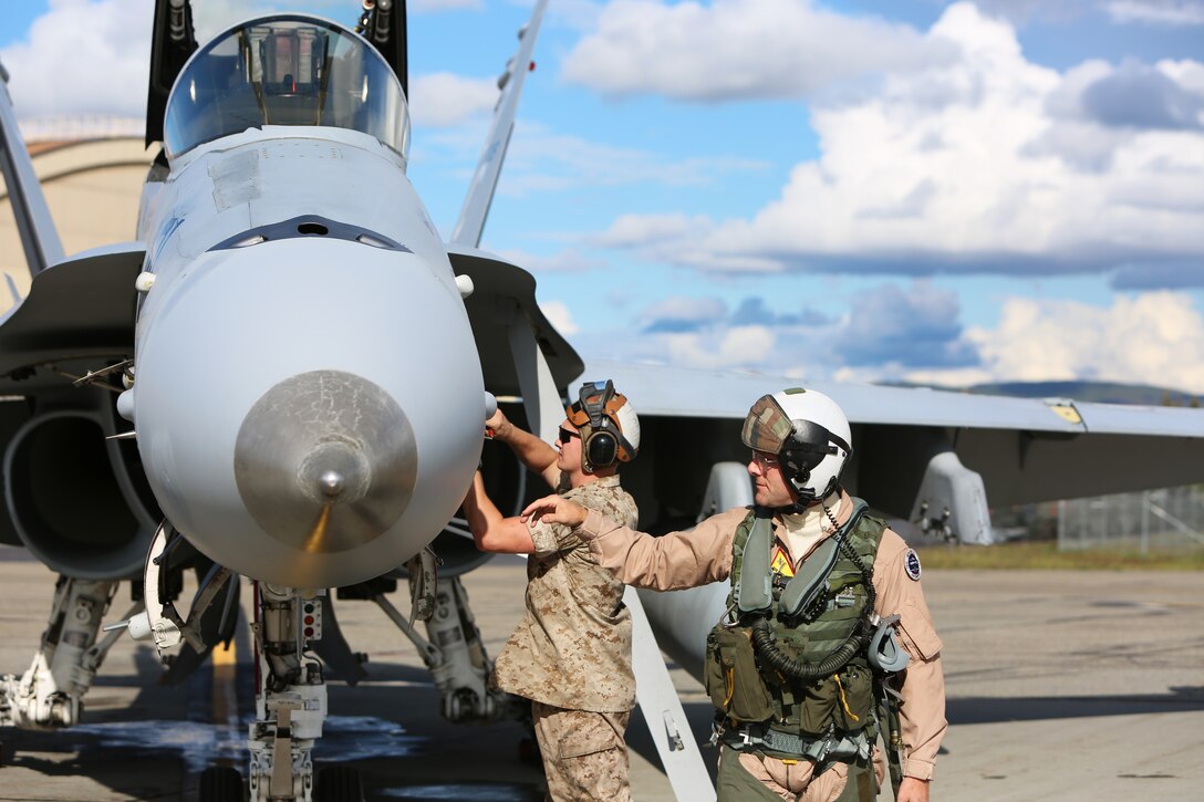 Col. William Lieblein, commanding officer of Marine Aircraft Group 31, and Lance Cpl. Dakota Cassell, a fixed-wing aircraft mechanic with Marine Fighter Attack Squadron 122, inspect an F/A-18C aboard Eielson Air Force Base, Alaska, August 25, 2014. Lieblein, who visited VMFA-122 from Marine Corps Air Station Beaufort, S.C., participated in the first flight of the squadron’s unit level training in Alaska. VMFA-122 arrived to Alaska from Hawaii and is scheduled to train with squadrons from the United States Air Force to enhance interoperability between services.  