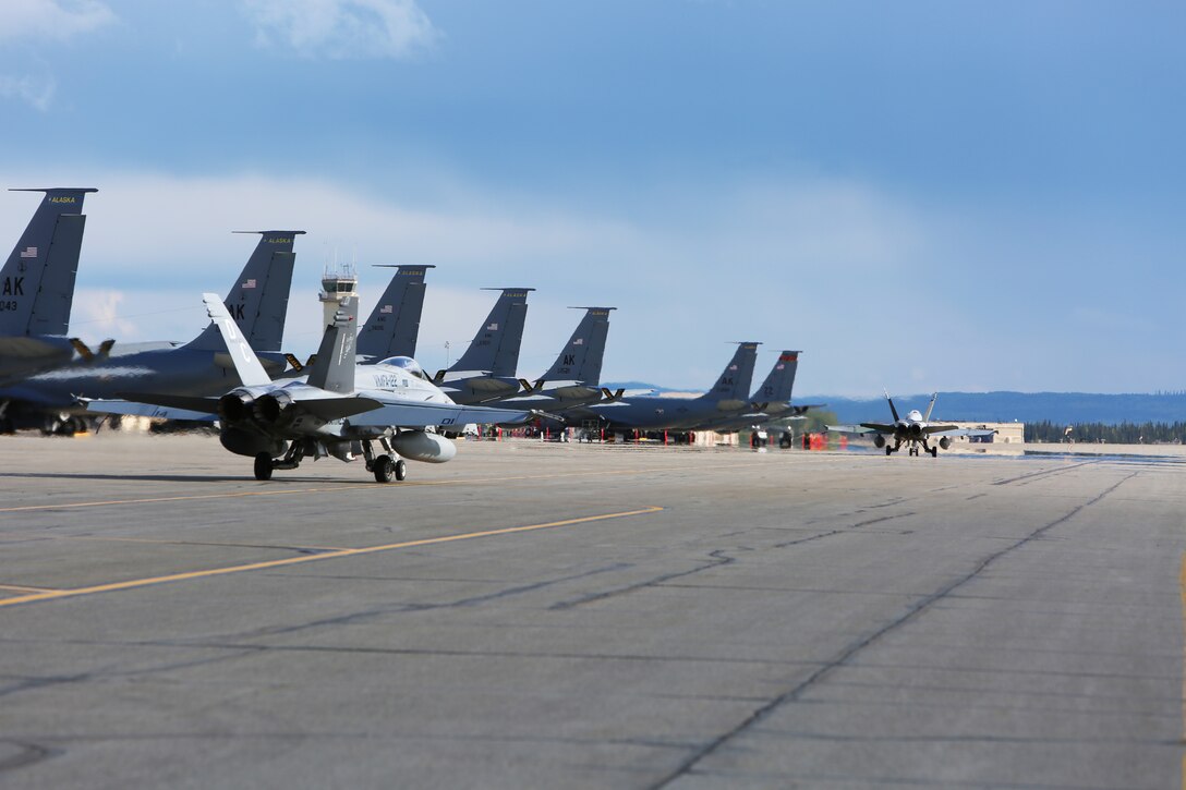Two F/A-18C aircraft with Marine Fighter Attack Squadron 122 taxi to the runway aboard Eielson Air Force Base Alaska, August 25, 2014. This was the first flight for the squadron during their unit level training in Alaska. In addition to ULT, VMFA-122, nicknamed the “Werewolves,” is scheduled to train with United States Air Force squadrons to enhance interoperability between services.