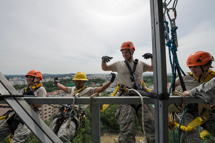 Staff Sgt. Aaron Ramelb (left) and Senior Airman Charlie Hegwer, both 51st Communications Squadron cable antenna technicians, teach Senior Airmen Lindy Pata, 51st Fighter Wing Public Affairs broadcaster, and Emma Duff, Armed Forces Network broadcaster, how to recline in their safety harnesses during a tower climbing and rappelling class Aug. 27, 2014, at Osan Air Base, Republic of Korea. Cable and antenna technicians can be required to work on tall structures as part of their duties, and are required to go through a yearly refresher on tower climbing and repelling procedures. (U.S. Air Force photo by Staff Sgt. Jake Barreiro/Released)
