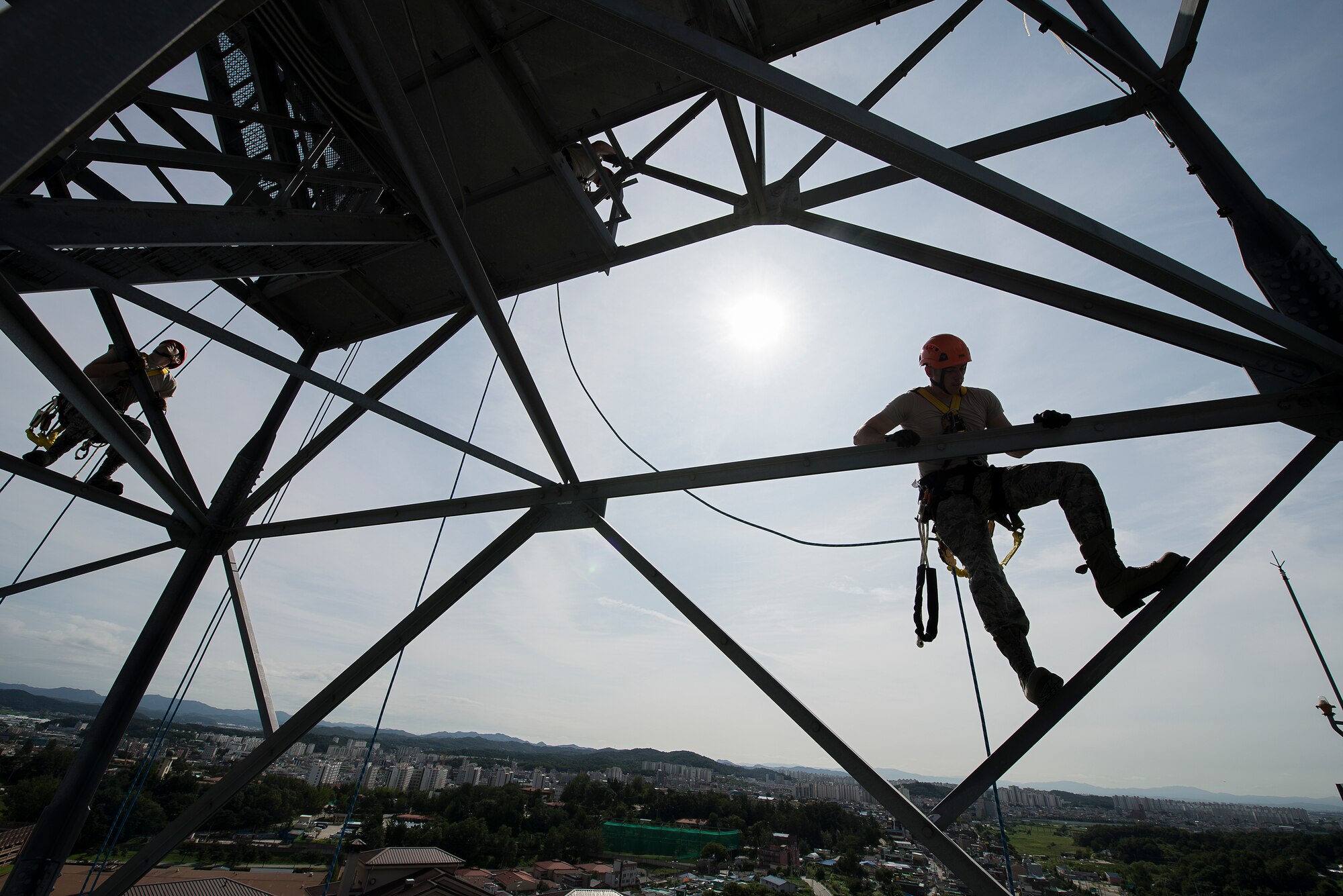 Airmen ascend during a tower climbing and rappelling class Aug. 27, 2014, at Osan Air Base, Republic of Korea. While rappelling, personnel are required to use safety harnesses and mantain three points of contact with the tower at all times. (U.S. Air Force photo by Staff Sgt. Jake Barreiro/Released)