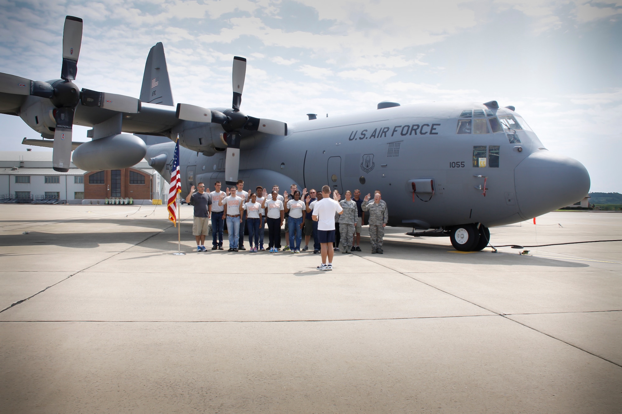 Col. Craig C. Peters reenlists eight Airmen of the 911th Airlift Wing along with nine members of the Development and Training Flight in front of a C-130 Hercules, Aug. 2, 2014 at the Pittsburgh International Airport Air Reserve Station. (U.S. Air Force photo by Senior Airman Justyne Obeldobel)
