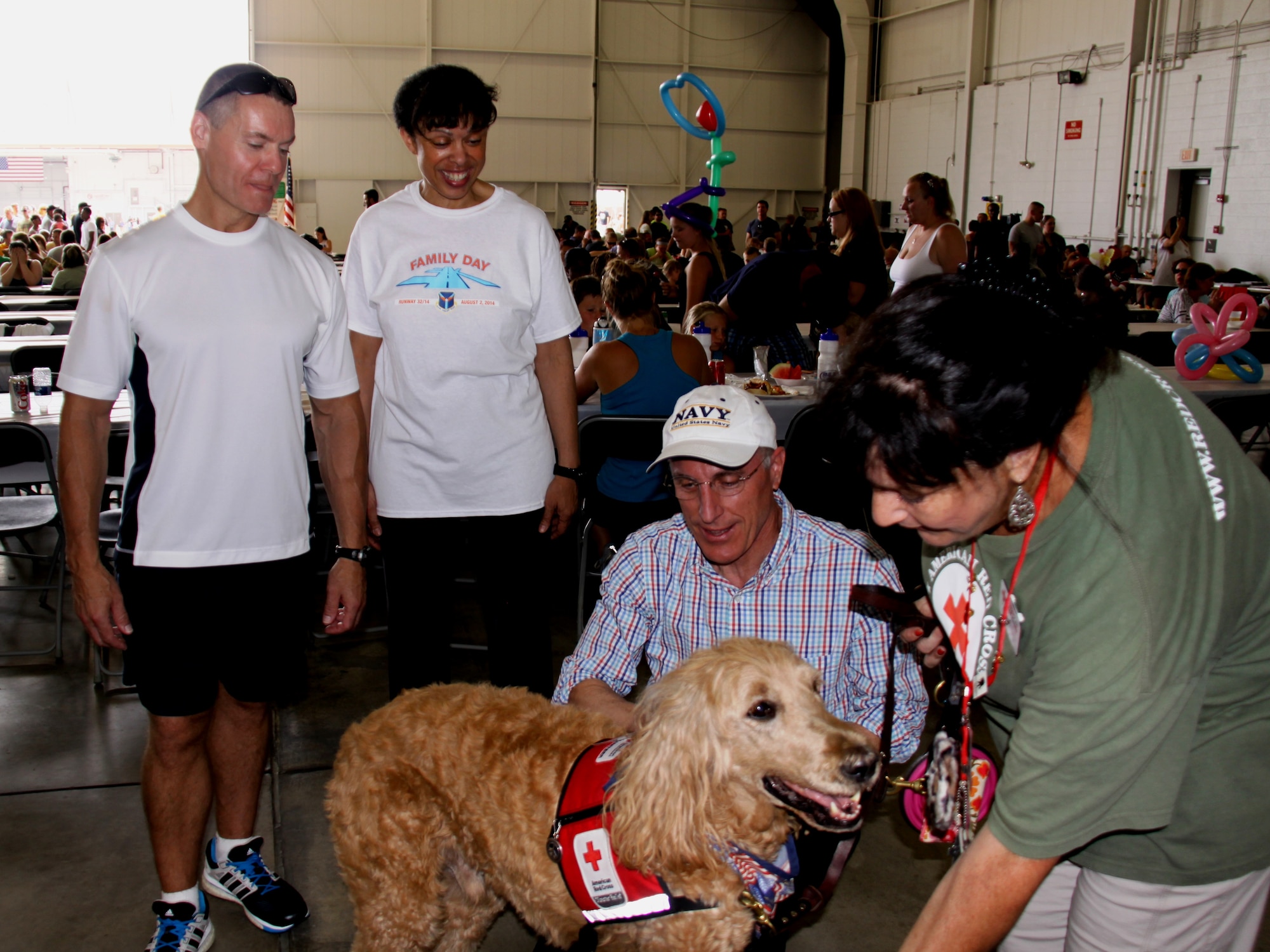 Col. Craig Peters and Maj. Gen. Stayce Harris, 22nd Air Force Commander, watch as U.S. Rep. Tim Murphy, R-Upper St. Clair, greets a Red Cross service dog during the 911th Airlift Wing family day event. (U.S. Air Force photo by Maj.  Jennifer Pearson)